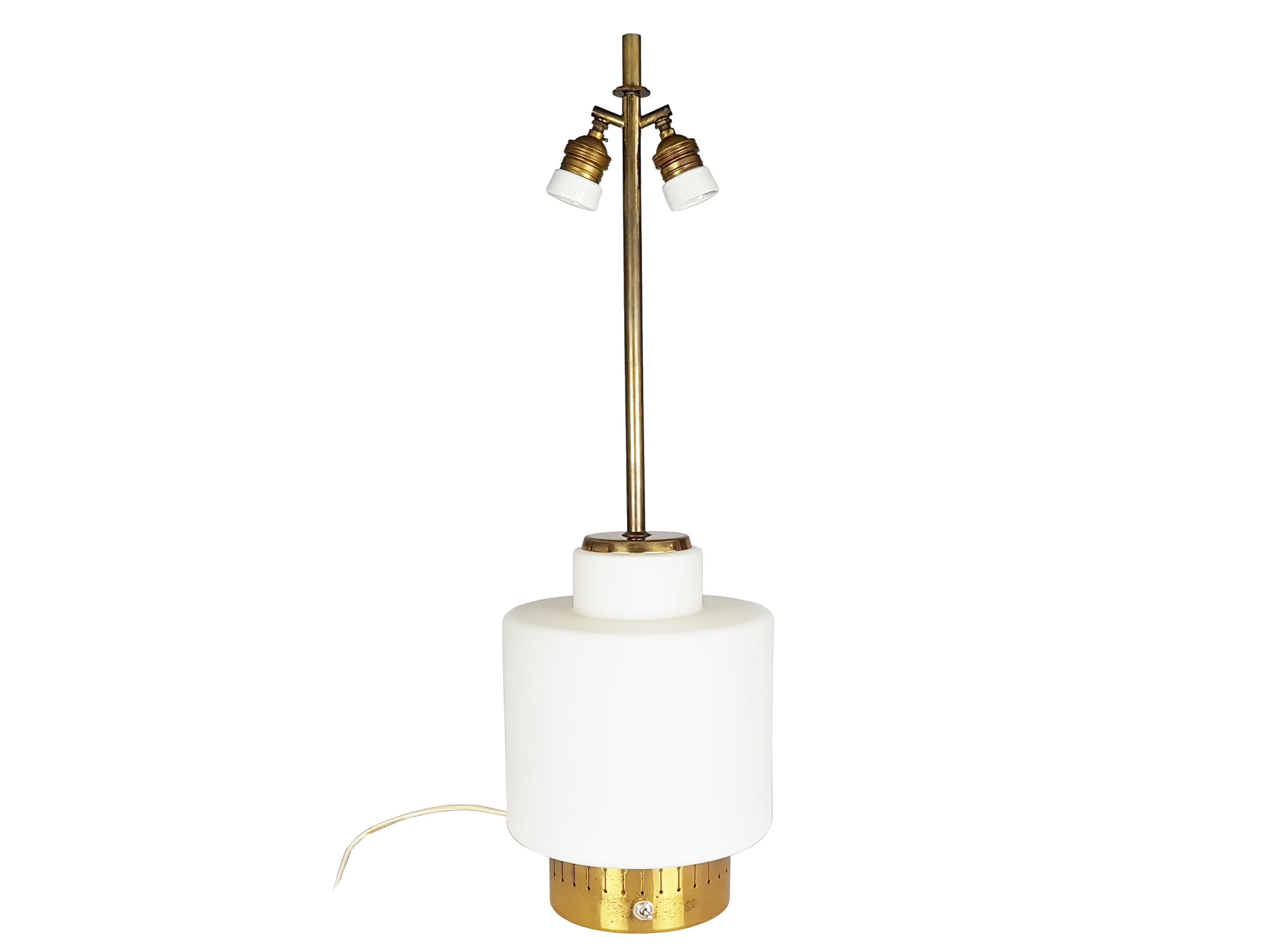 This elegant abat jour was designed and produced by Stilnovo in the late 1950s. It is made from a white opaline glass shade with an elegant brass structure. A switch on the base manages the simultaneous lighting of 3 bulbs: one internal and two