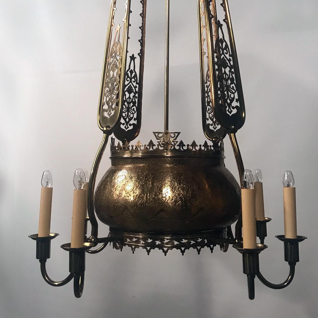 An antique Orientalist chandelier, the central Islamic brass bowl is finely
hand-engraved with scenes and forms the main focus of this late 19th century French chandelier which takes up the theme and adds the fretwork brass panels and various