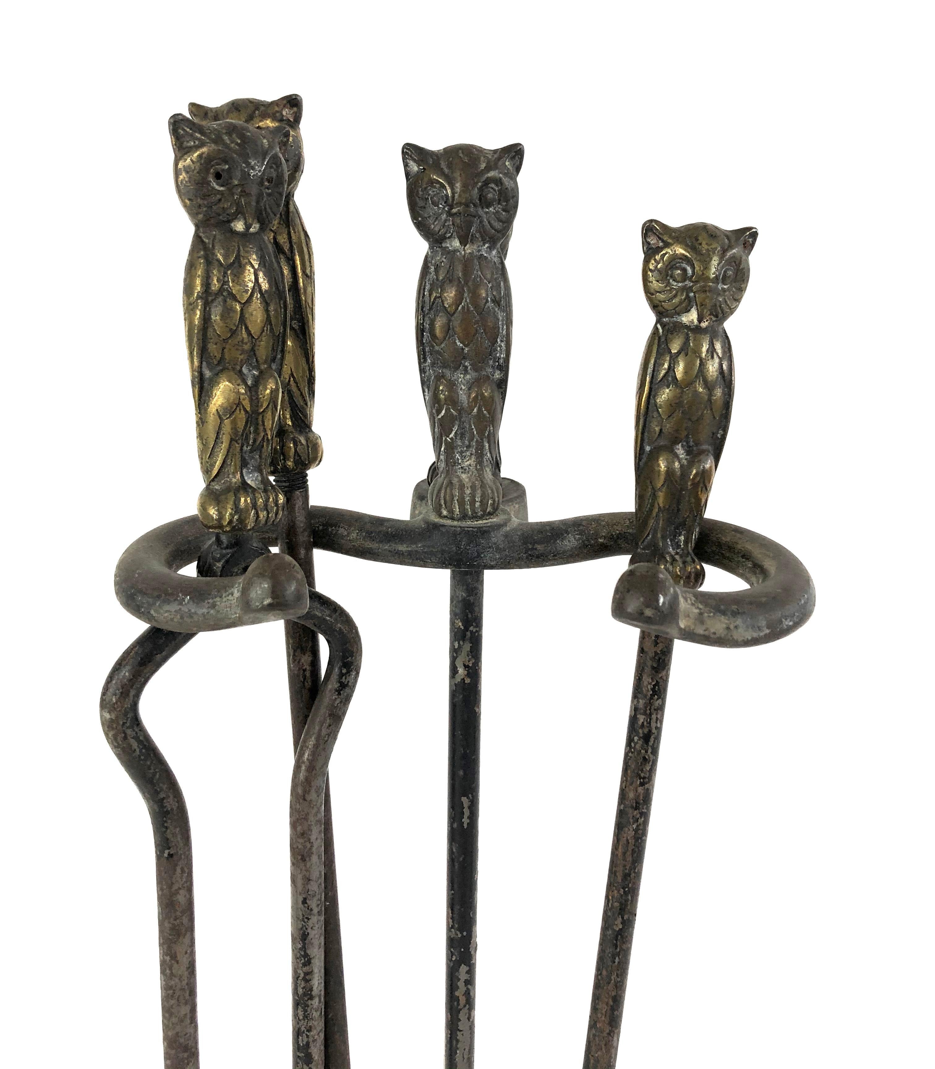 A set of brass and cast iron fireplace tools, each with a well model figure of a brass owl as its handle, comprising tongs, a poker, broom, and shovel on a stand. Solid and well made with good patina.

Dimensions:
Overall height 27.5