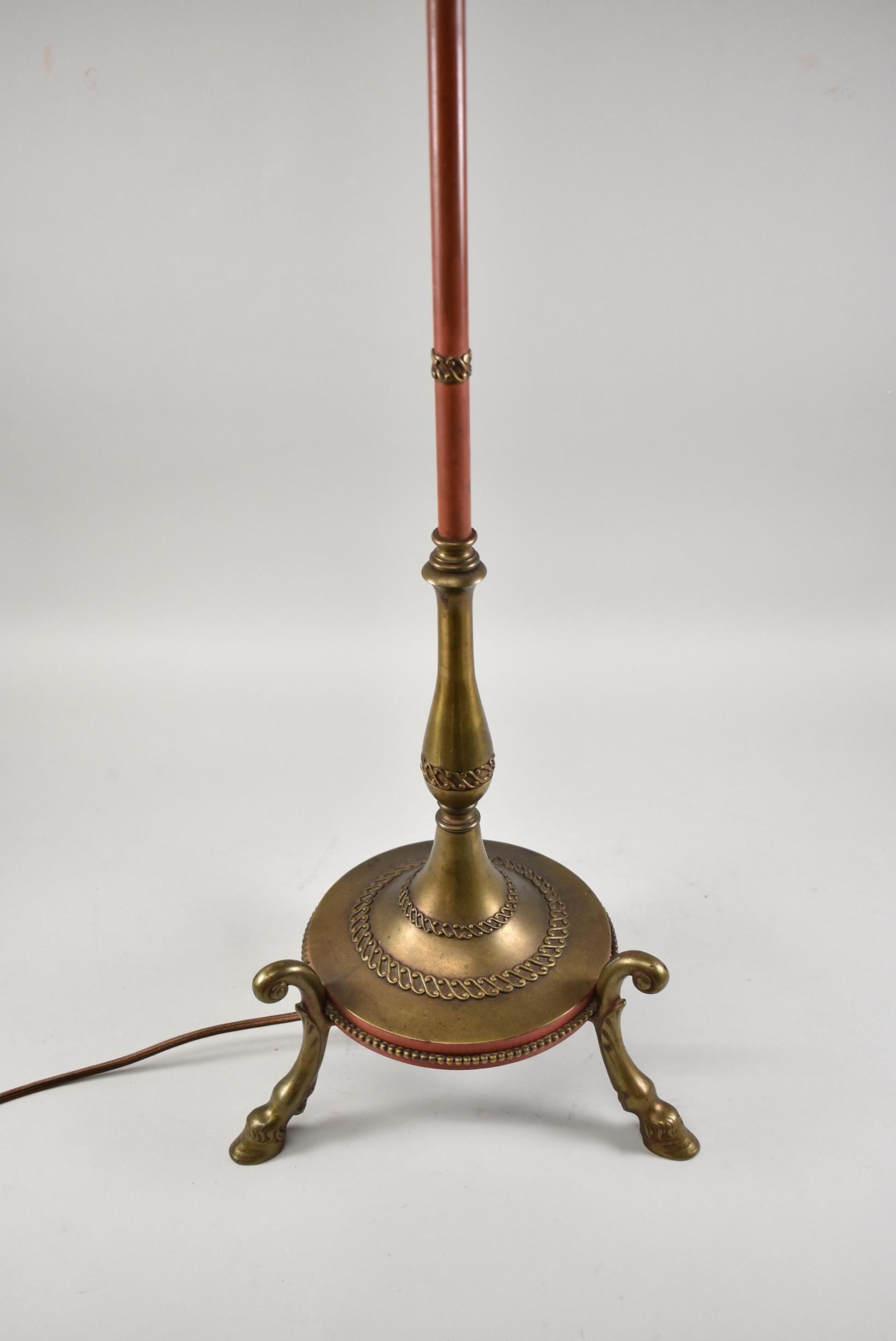 Brass and painted floor lamp with hoof footed base and figural cherubs. Three sockets, circa 1910-1920. Shade is not included.