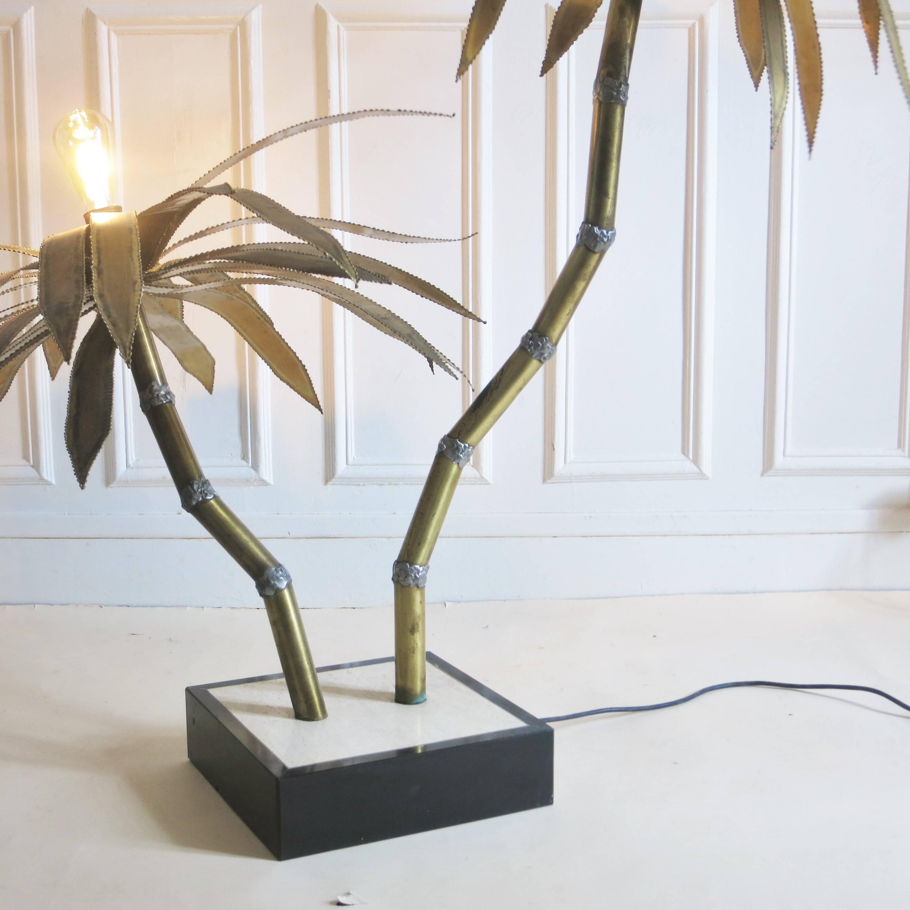 Palm tree floor lamp of the 1970s in brass on a marble and travertine square base. French Design of the 1970s in the style of the Hollywood Regency.