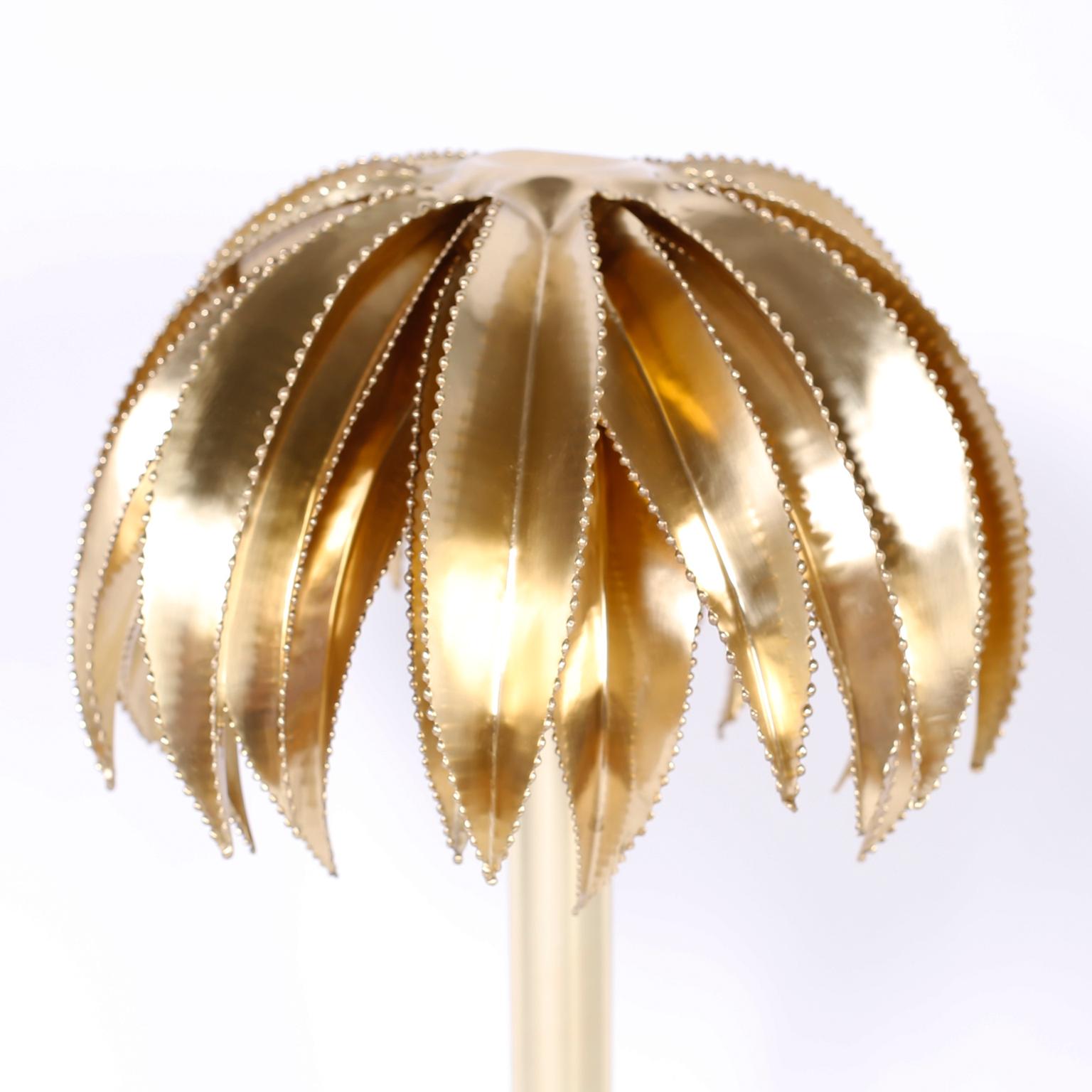 Midcentury brass palm tree sculpture with Brutalist style cerated edges, sleek stylized trunk, and presented on a Lucite base.