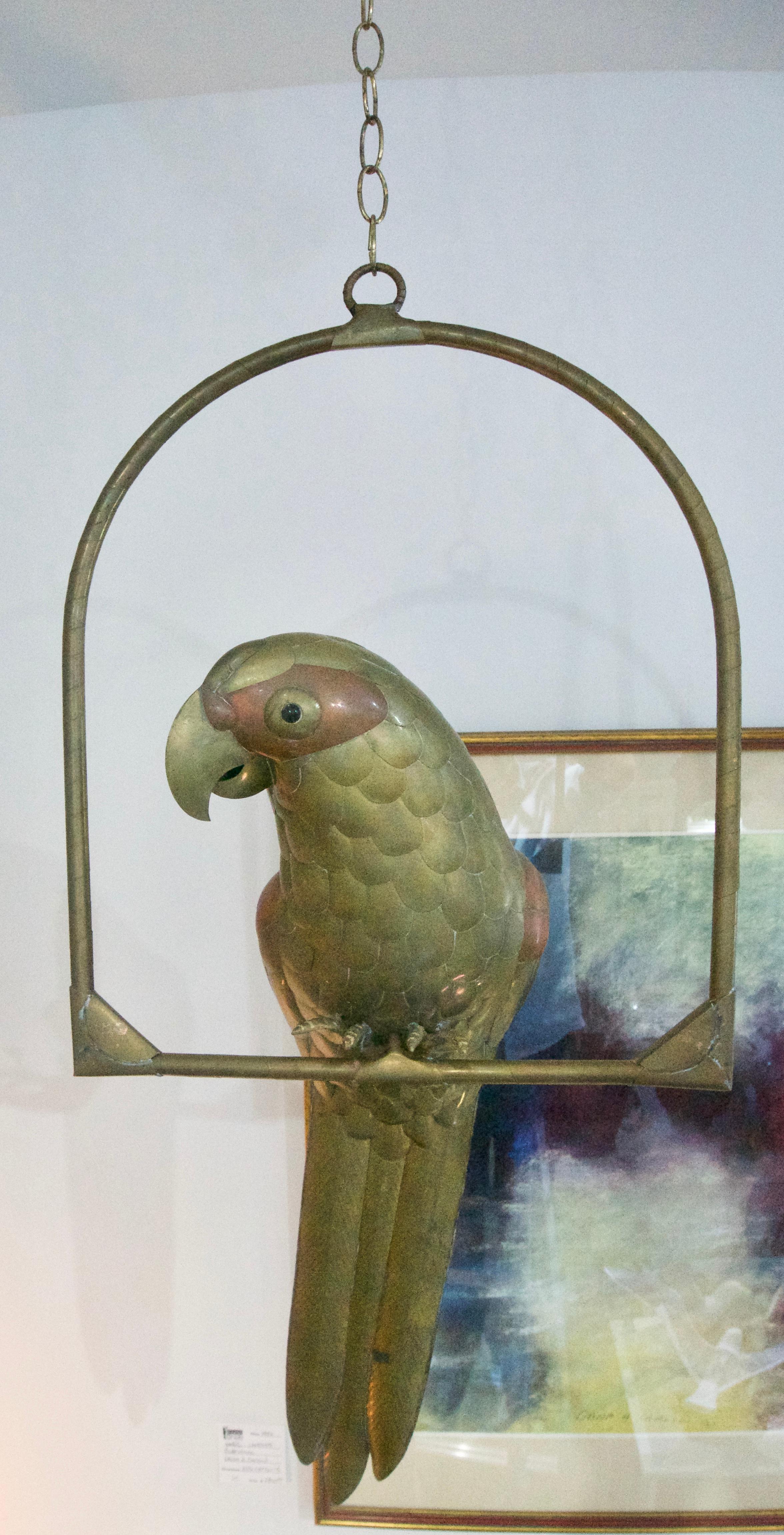 This charming life-size brass and copper Macaw parrot sculpture is by the renowned designer Sergio Bustamante and dates to the 1960s

Dimensions:  From bottom of parrots tail feathers to the top of the round ring is 33