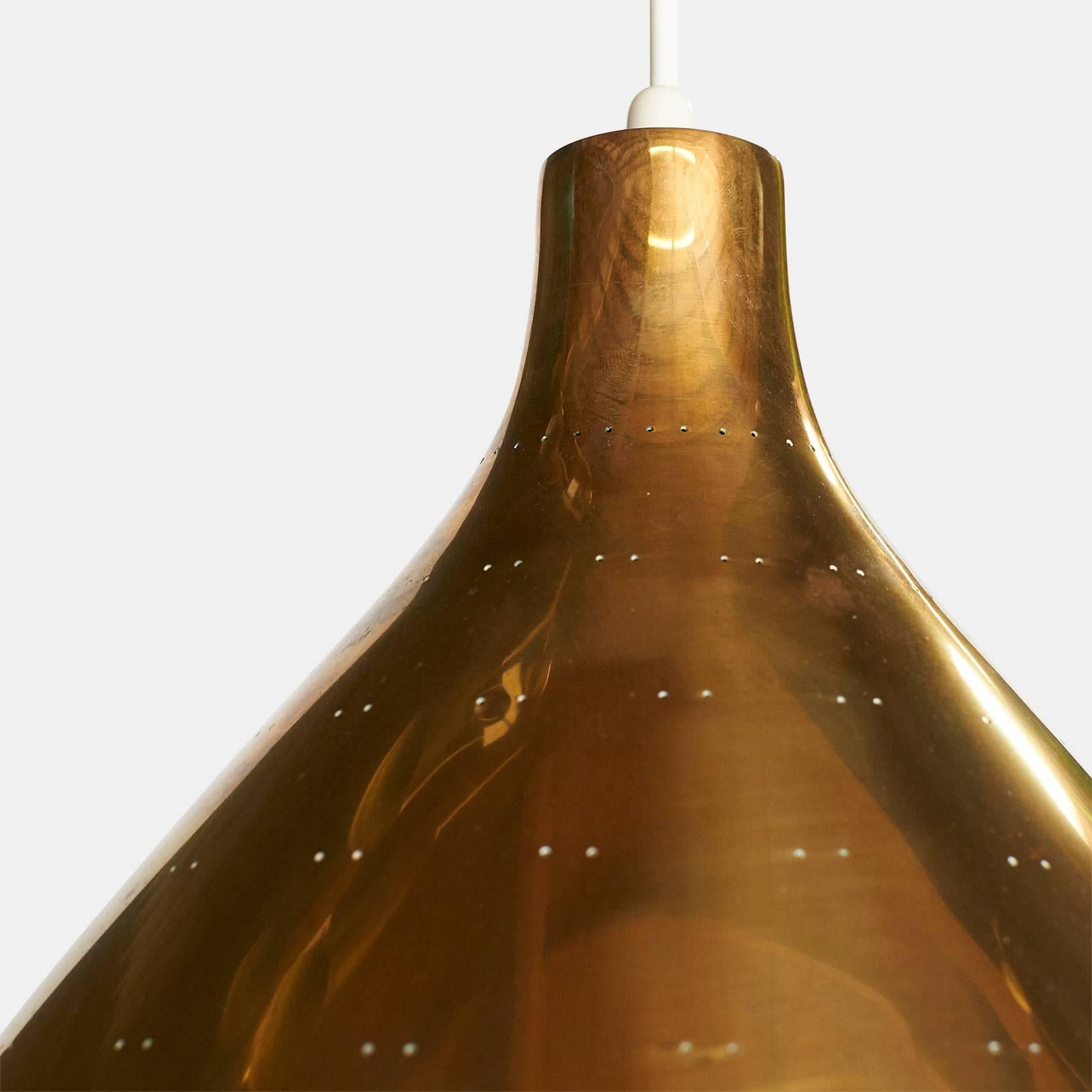 A large edition of the K2-46 chandelier by Paavo Tynell for Idman. The brass shade has twin dot perforations, scalloped edge detail, and a etched glass diffuser underneath. The overall length can be adjusted and specified,
Finland, circa 1950s.