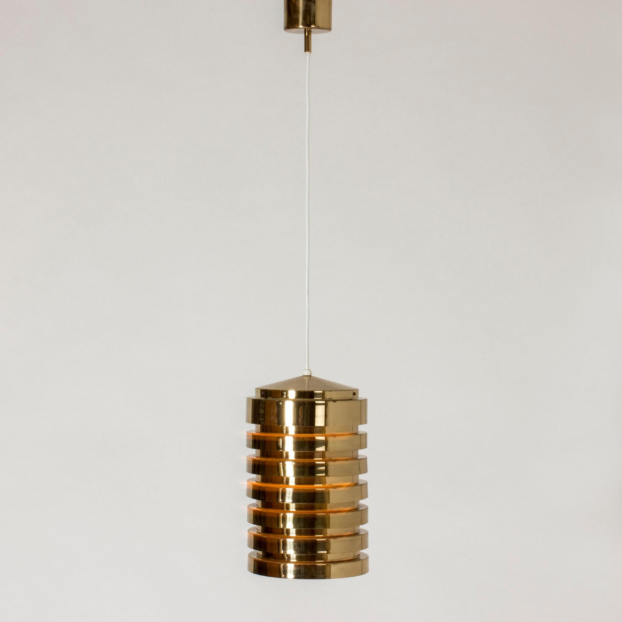 Brass cylinder shape pendant lamp by Hans-Agne Jakobsson, made from lamellas that let out the light warmly between them.