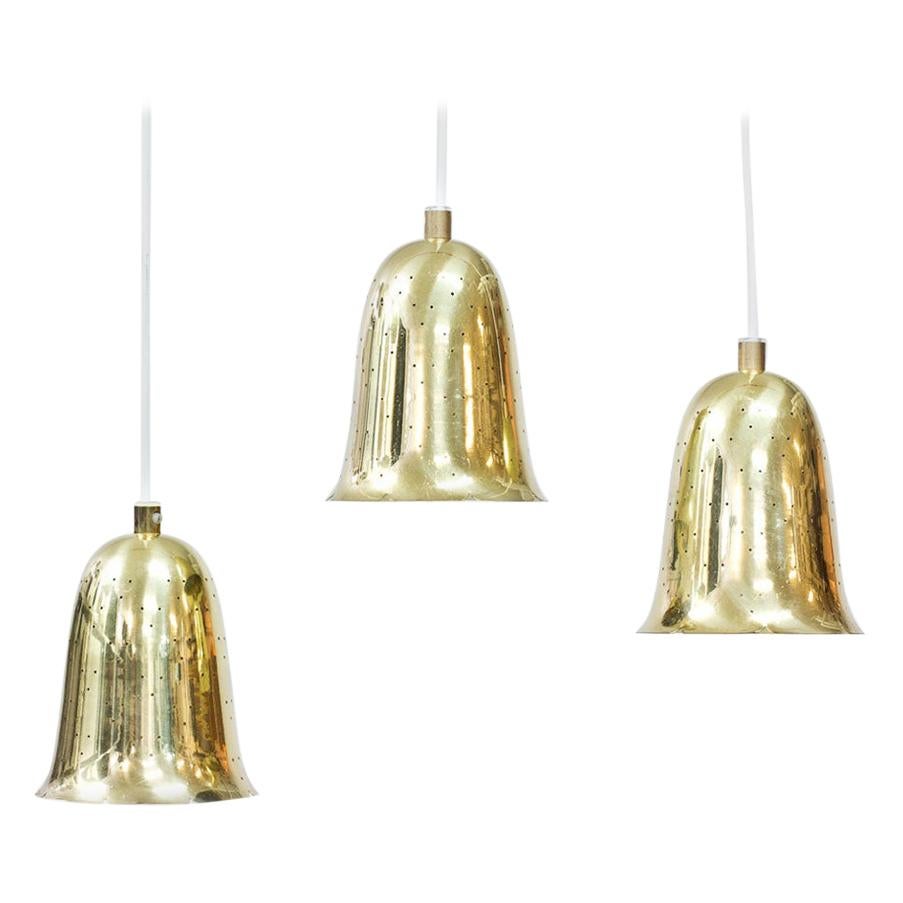 Beautiful set of three bell shaped pendant lamps produced by Boréns at Borås in Sweden during the 1950s. 
Lamps made out of perforated polished solid brass. New electricity.