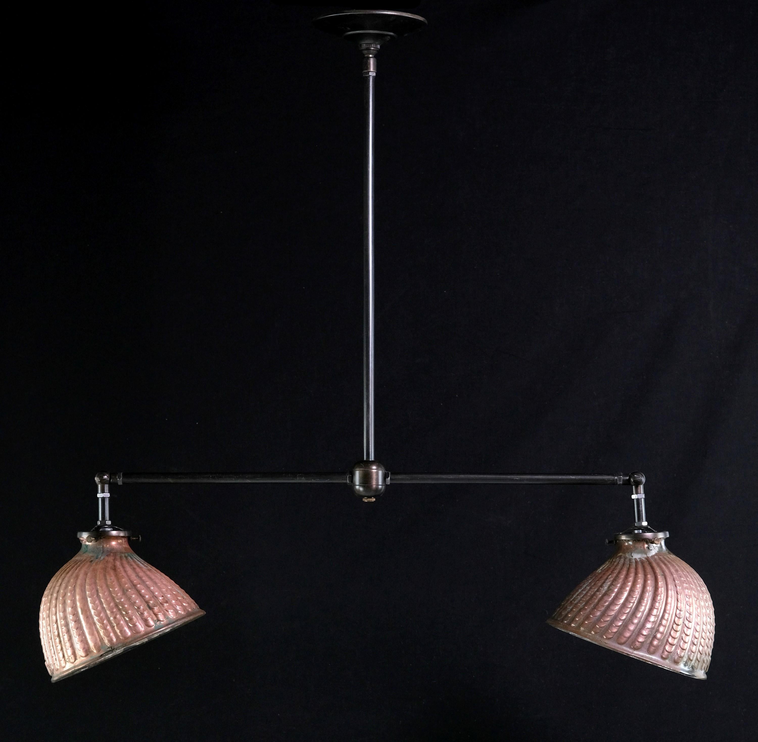 Two original 1910s copper plated mercury glass shades are repurposed into this double headed brass pendant light. Great for kitchen islands. These unique shades are of a clam shell shape and have a unique ripple pattern molded into the glass. The
