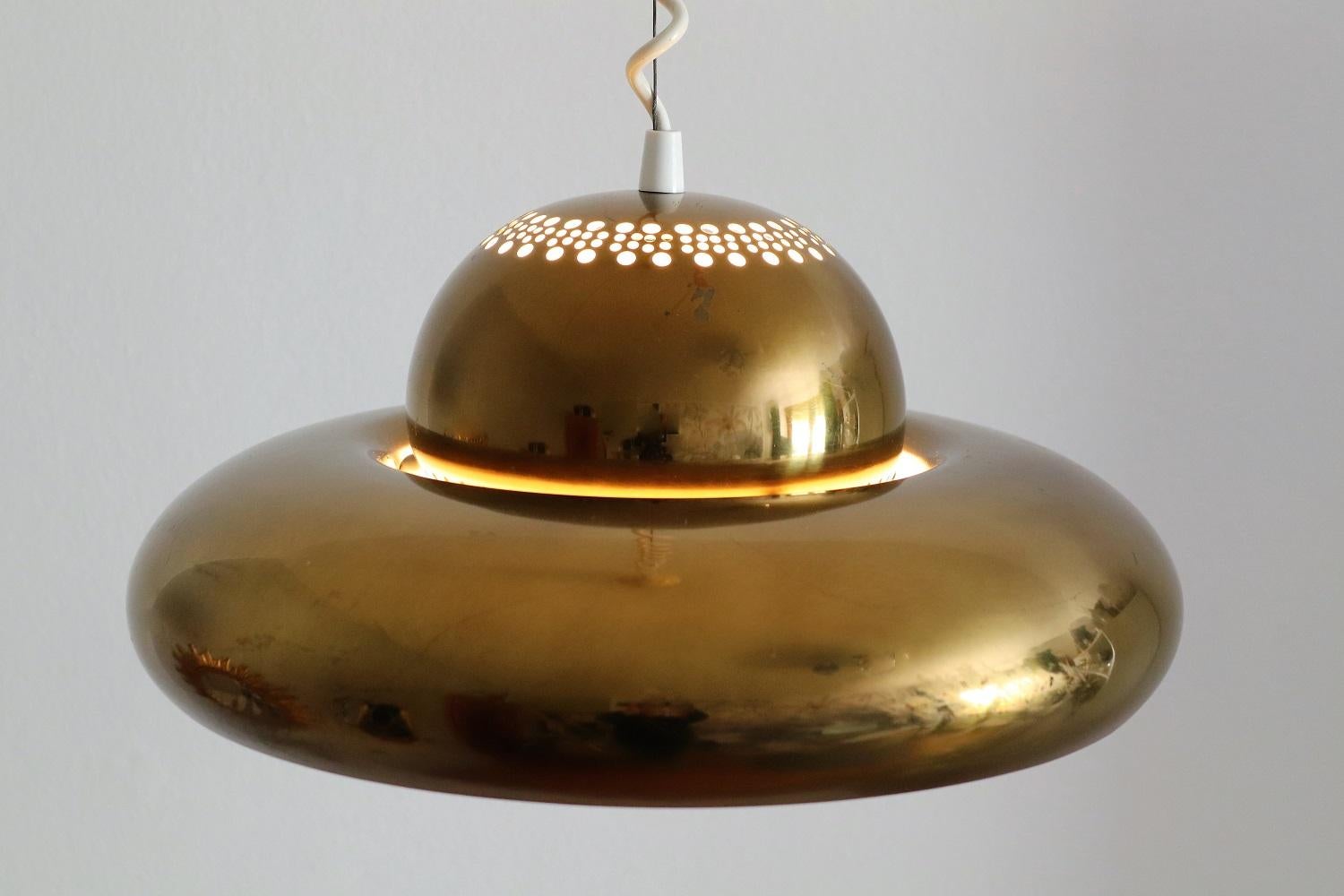 Gorgeous pendant lamp in full brass with dark patina and signs of wear, designed by Afra and Tobia Scarpa and manufactured by Flos in the early 1960s, Italy. Since many years out of production.
The pendant is in original version with curly cable