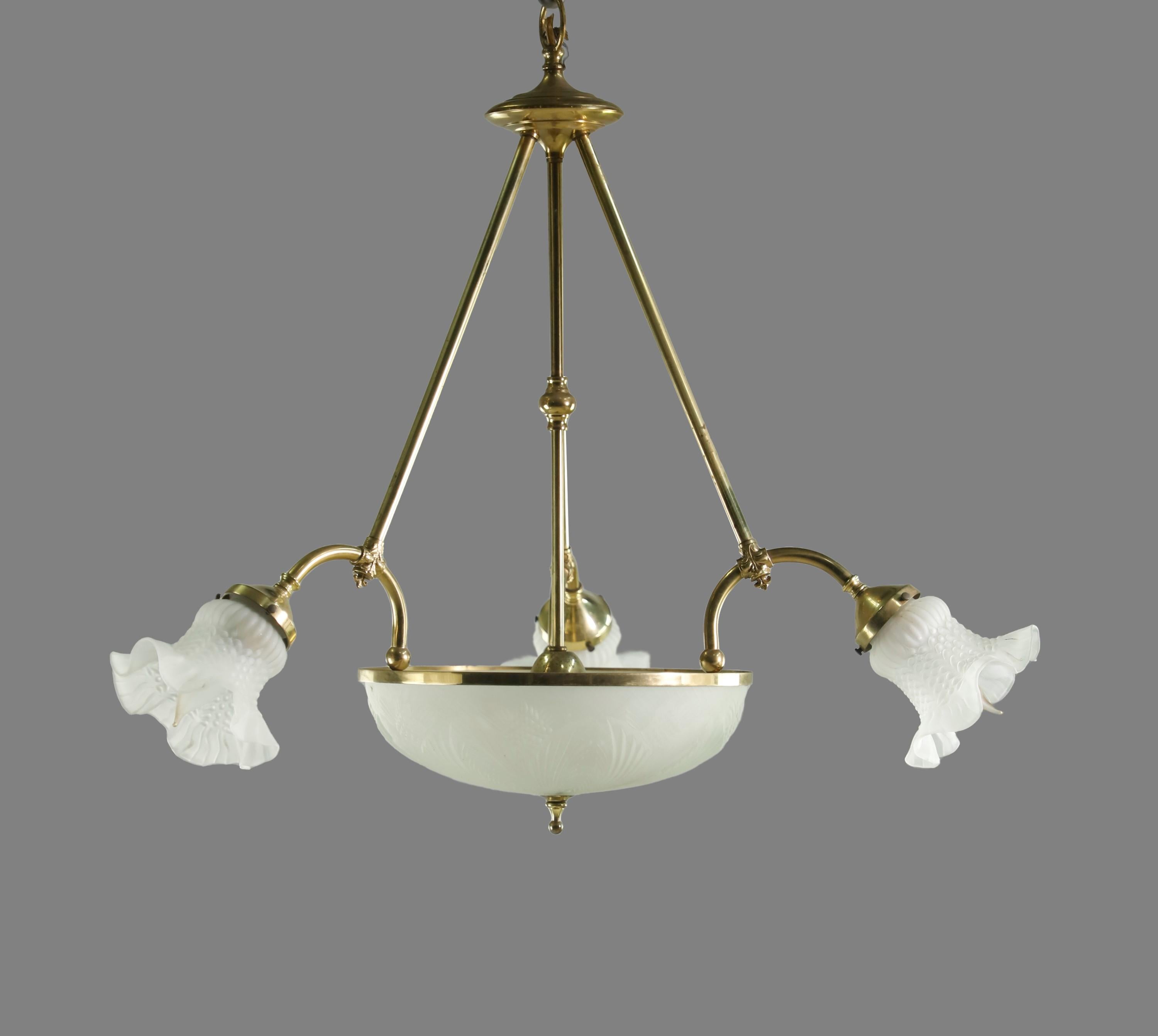 20th century pendant light in brass. Features 3 outstretched arms and one center dish. 5 sockets total, 3 candelabra Size in the arms and 2 base medium base Size in the center dish. Molded floral shades and dish. This will be cleaned and restored