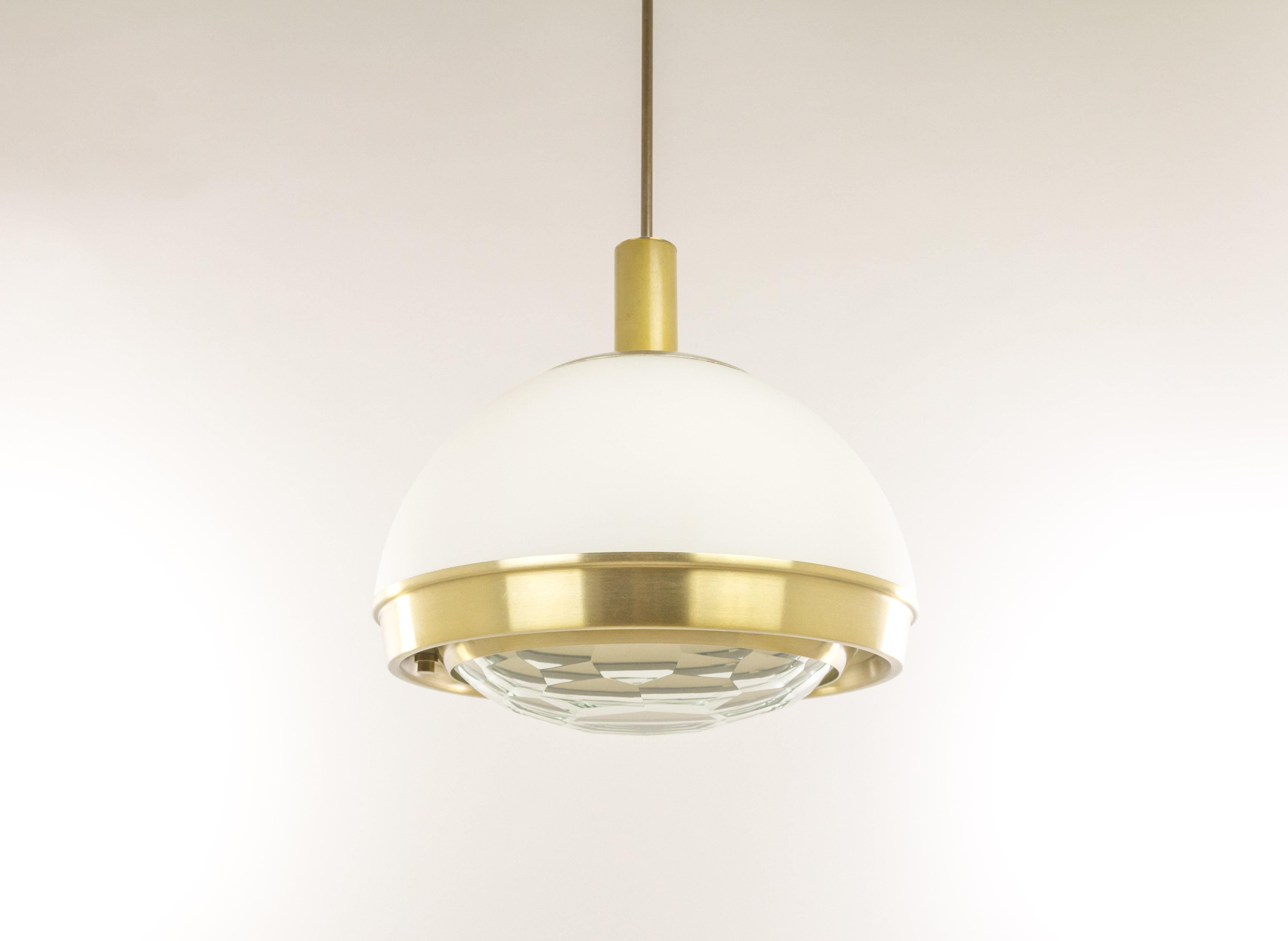 Faceted glass pendant by Italian lighting designer Pia Guidetti Crippa for Lumi Milano, 1960s.

Brass rings hold a white milk glass shade with at the bottom a facet cut clear crystal lens for a beautiful light experience.

Three-light sources.
