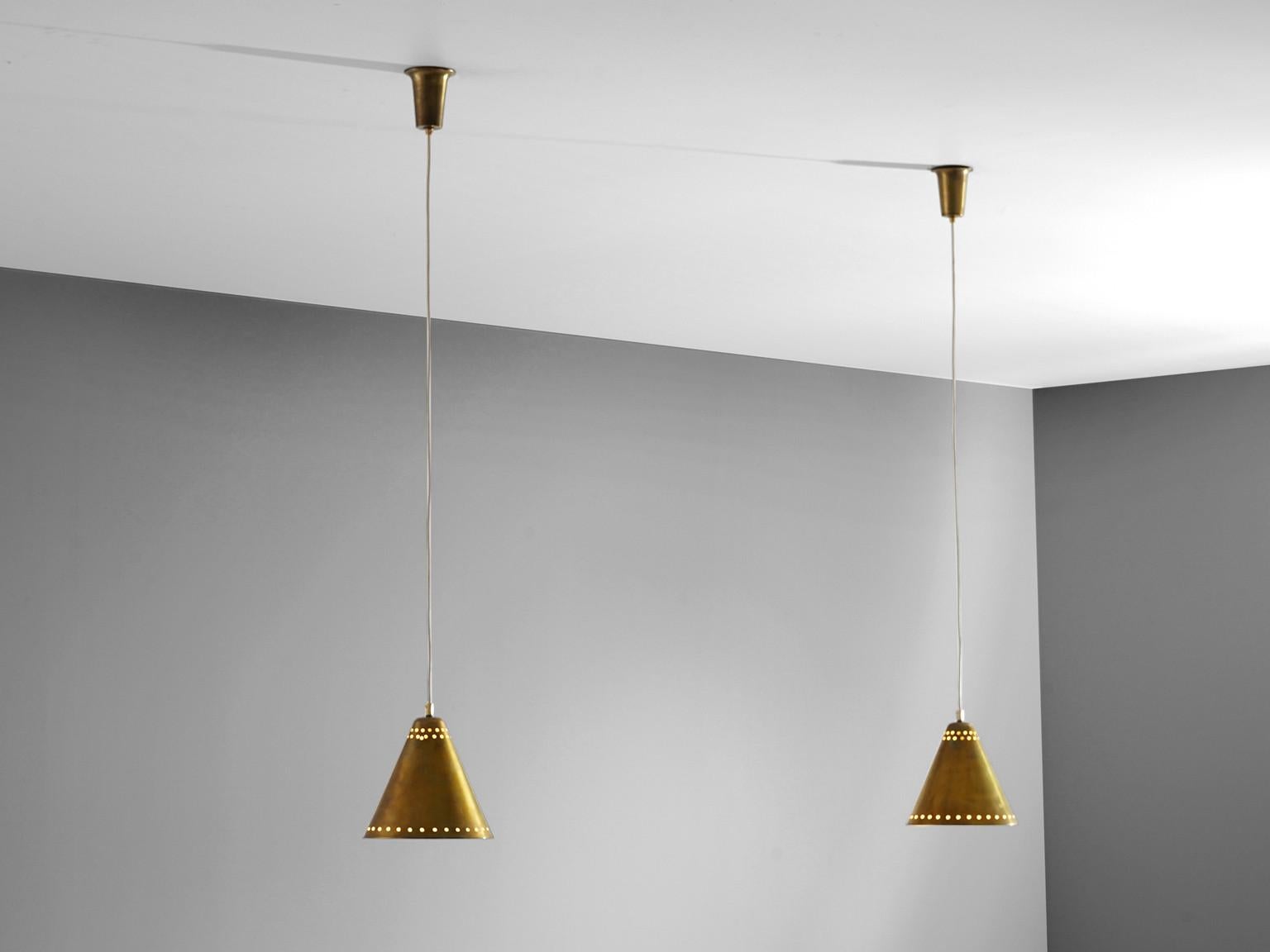Pendants, brass, Italy, 1950s 

Two solid brass pendants in the style of Stilnovo. The shades have a perforated edge on the outer border and are double perforated around the centre of the shade as well. Both pendants come with their original