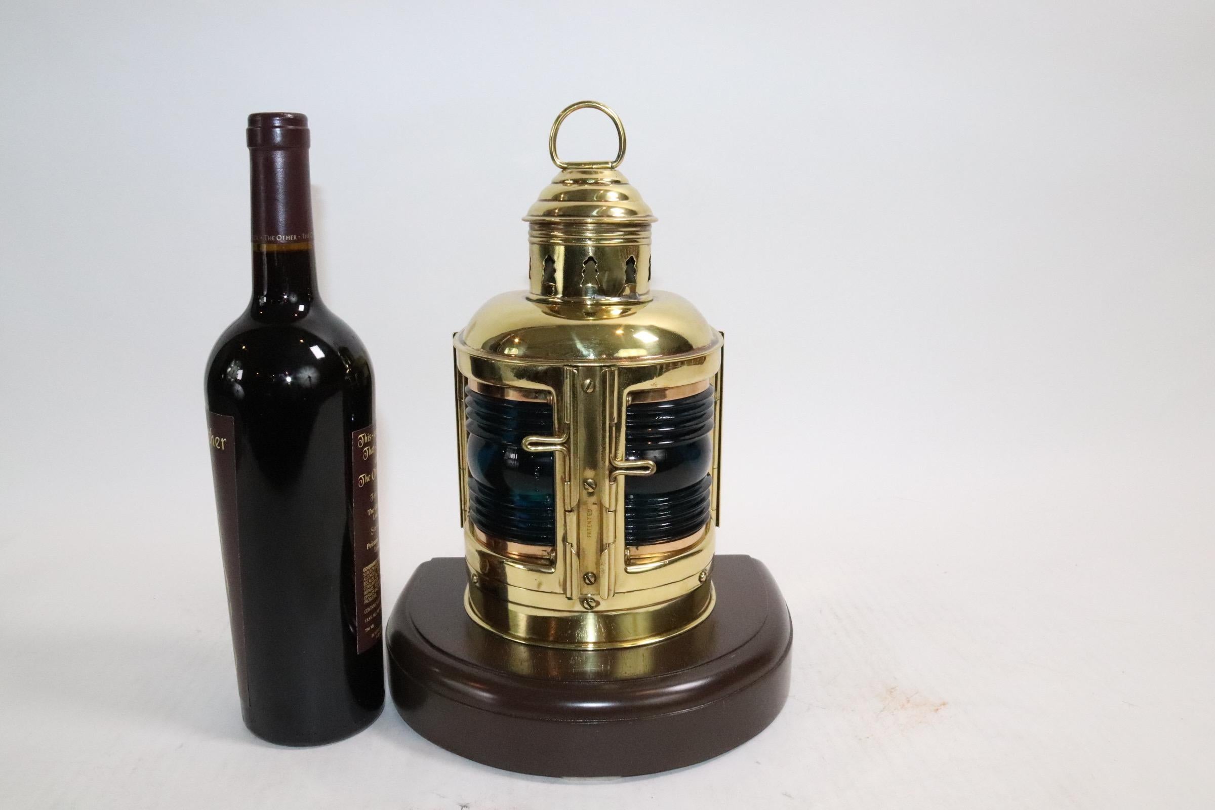 Highly polished and lacquered boat lantern by Perko. With original oil burner and wick. Fitted with two rich blue lenses and mounted to a thick wood base. Weight is 6 pounds.