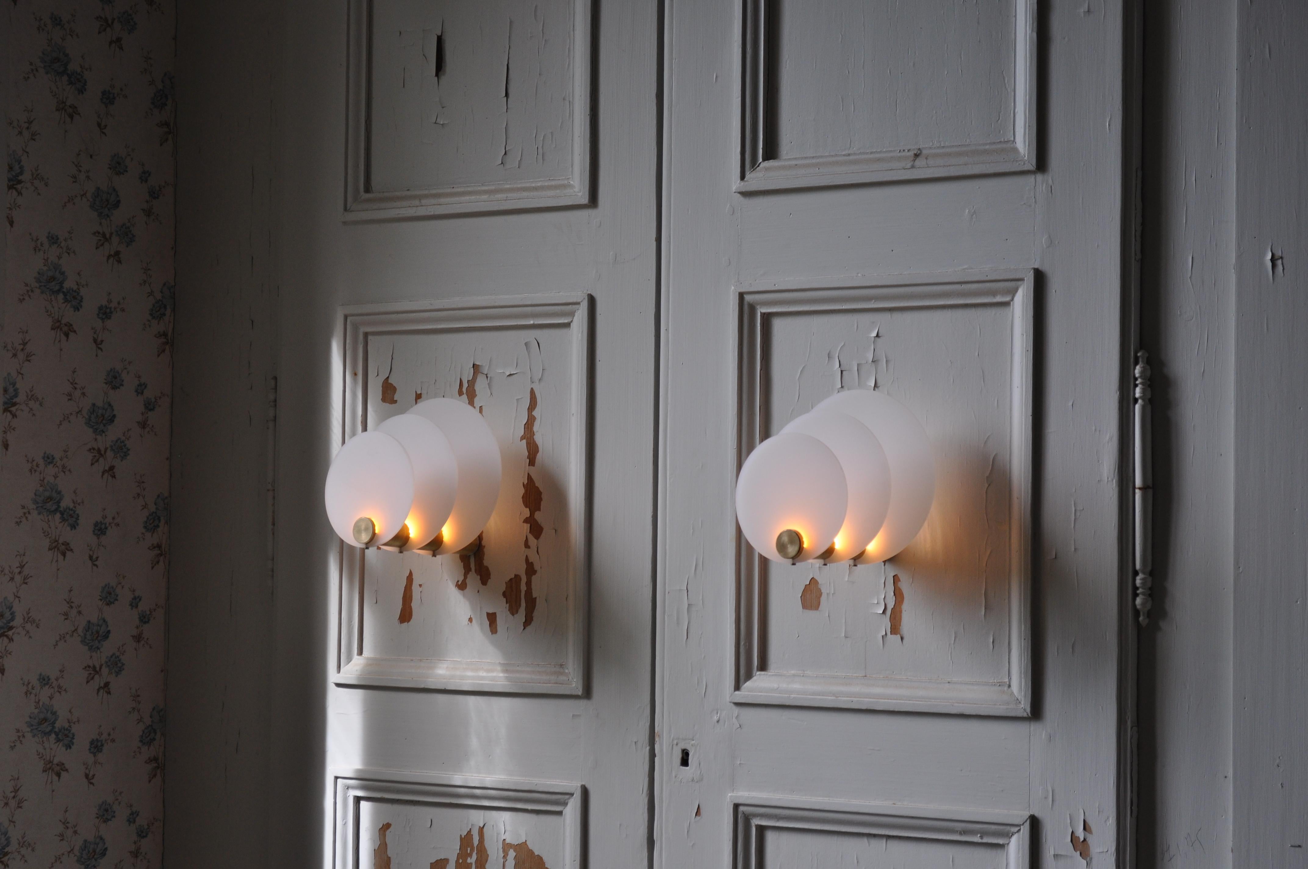 Oresta designed those sconces to share the Scandinavian winter atmosphere. Those wall lamps are made of a brass tube which let the light reflect into perspex rings. Each ring is 0.8 cm wide. The perspex is made to let the light spread into it. The