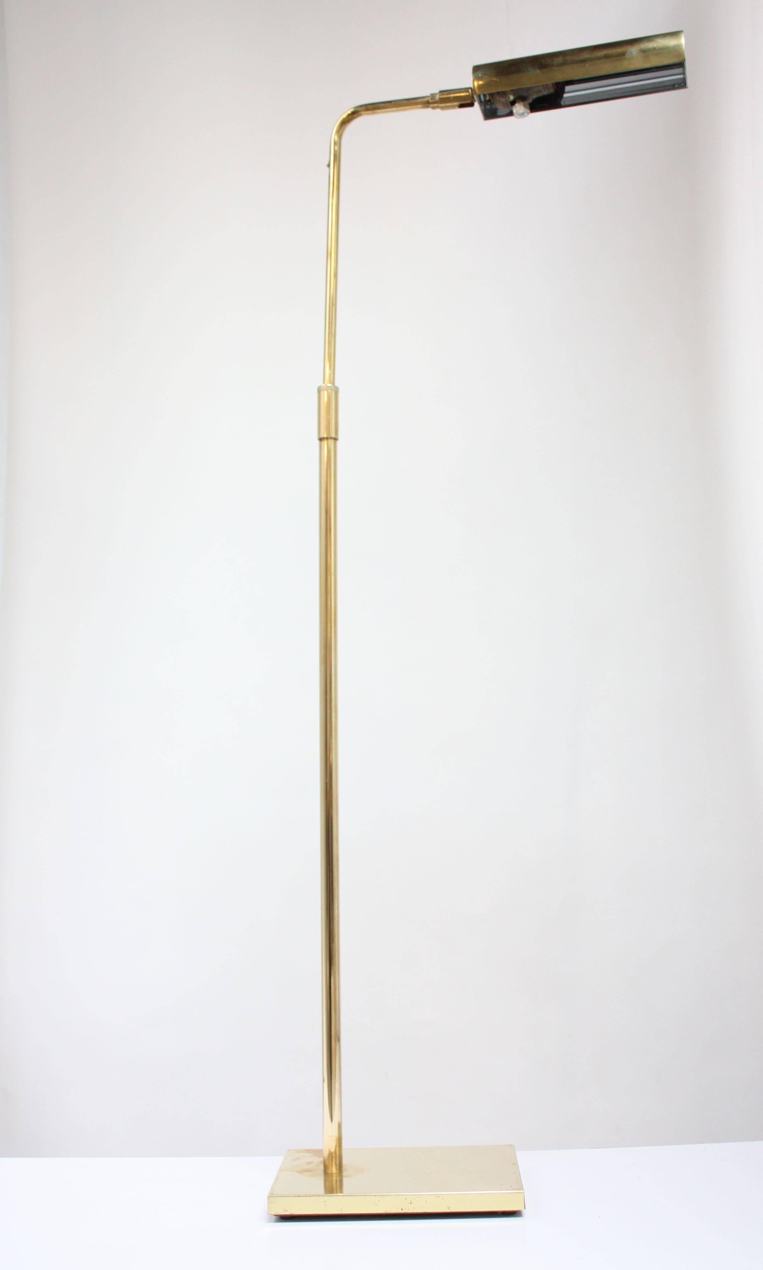 This minimal, yet versatile brass pharmacy floor lamp from Koch and Lowy is composed of an adjustable and swiveling shade. Additionally, the height can be adjusted. There is wear to the base, but the lamp has been polished and otherwise shows