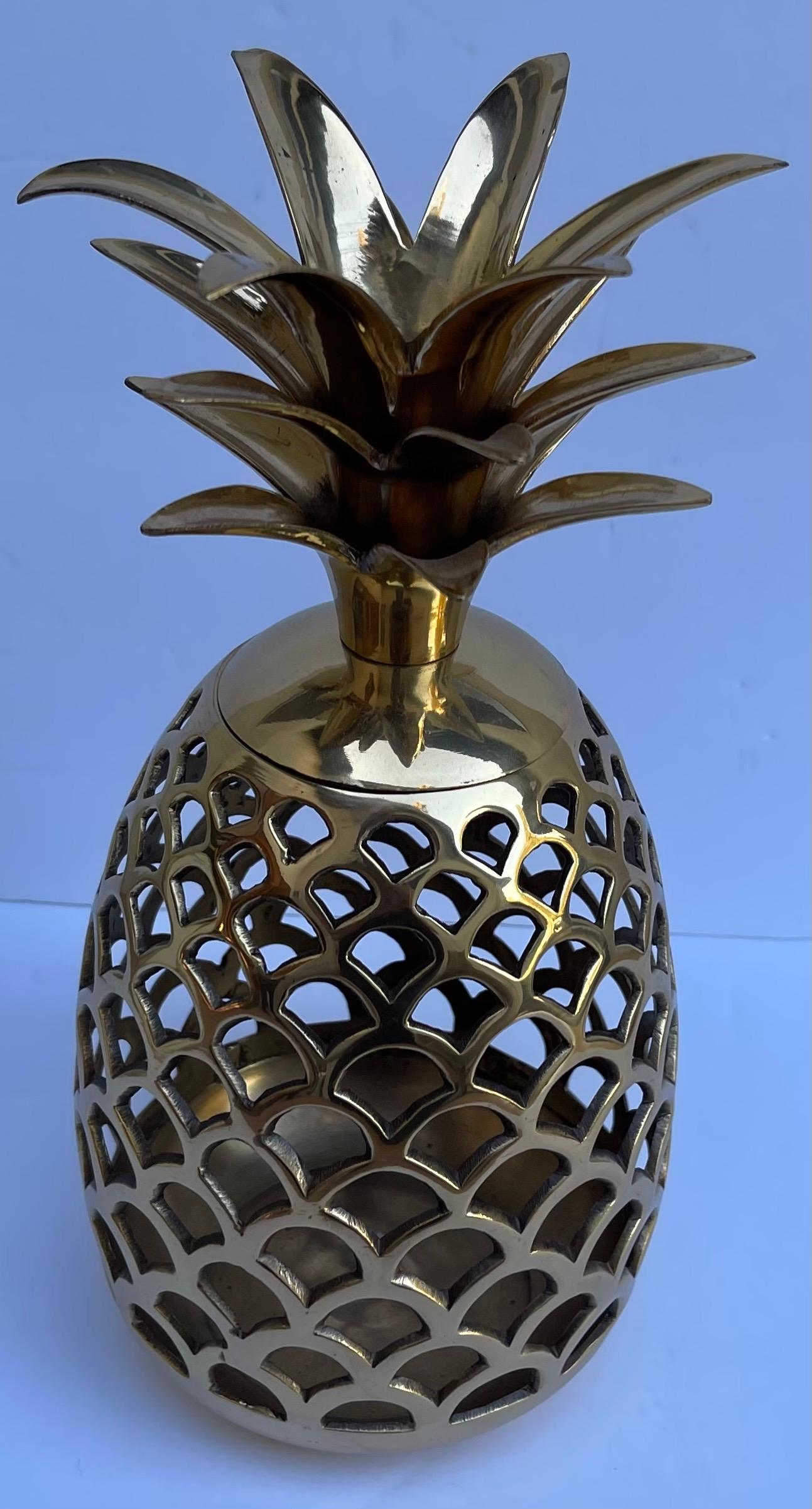 Grande portacandele in ottone lucido con ananas forato. Coperchio rimovibile. Accoglie una candela a colonna (non inclusa).