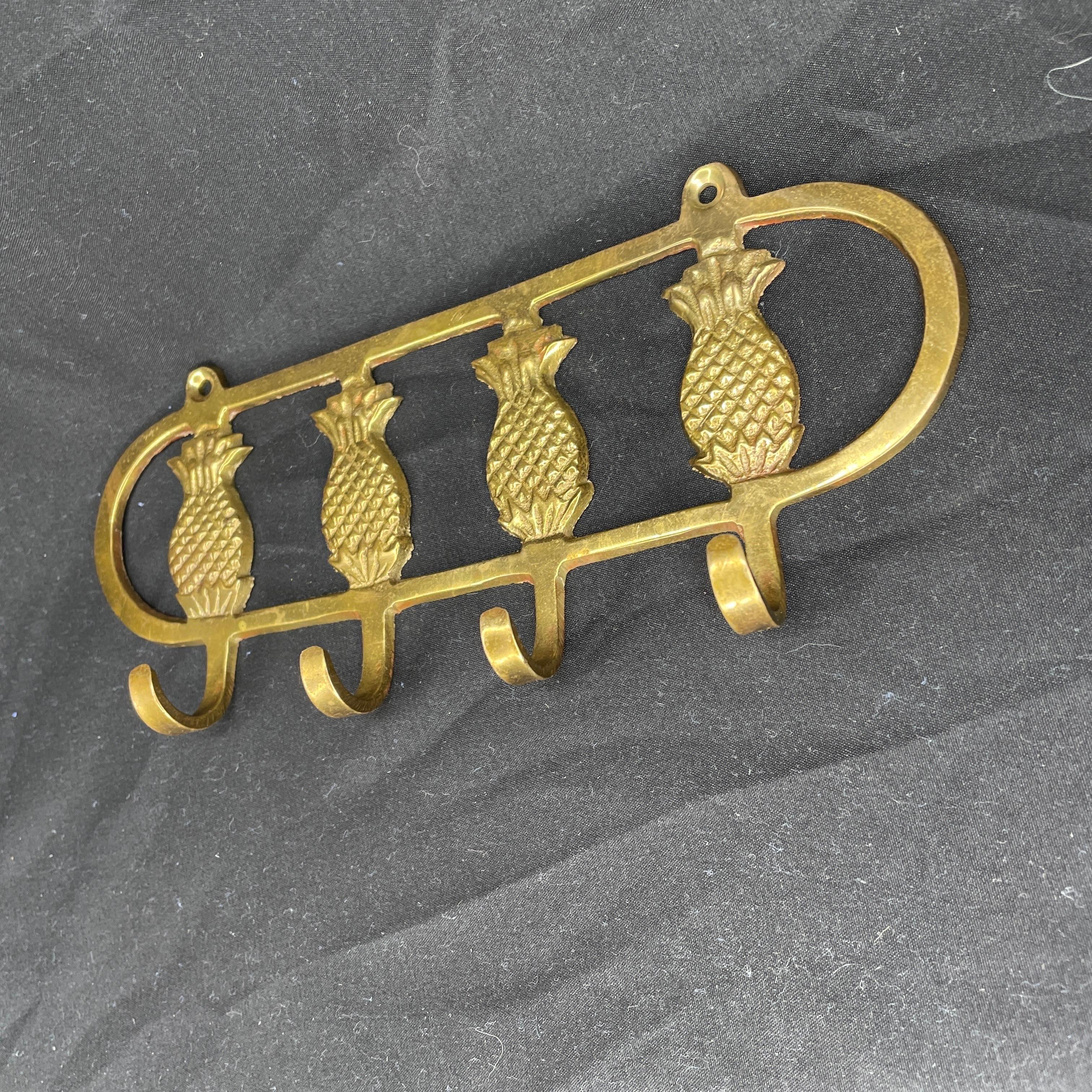 Brass wall key holder composed of four pineapples with four hooks. In very good condition. 