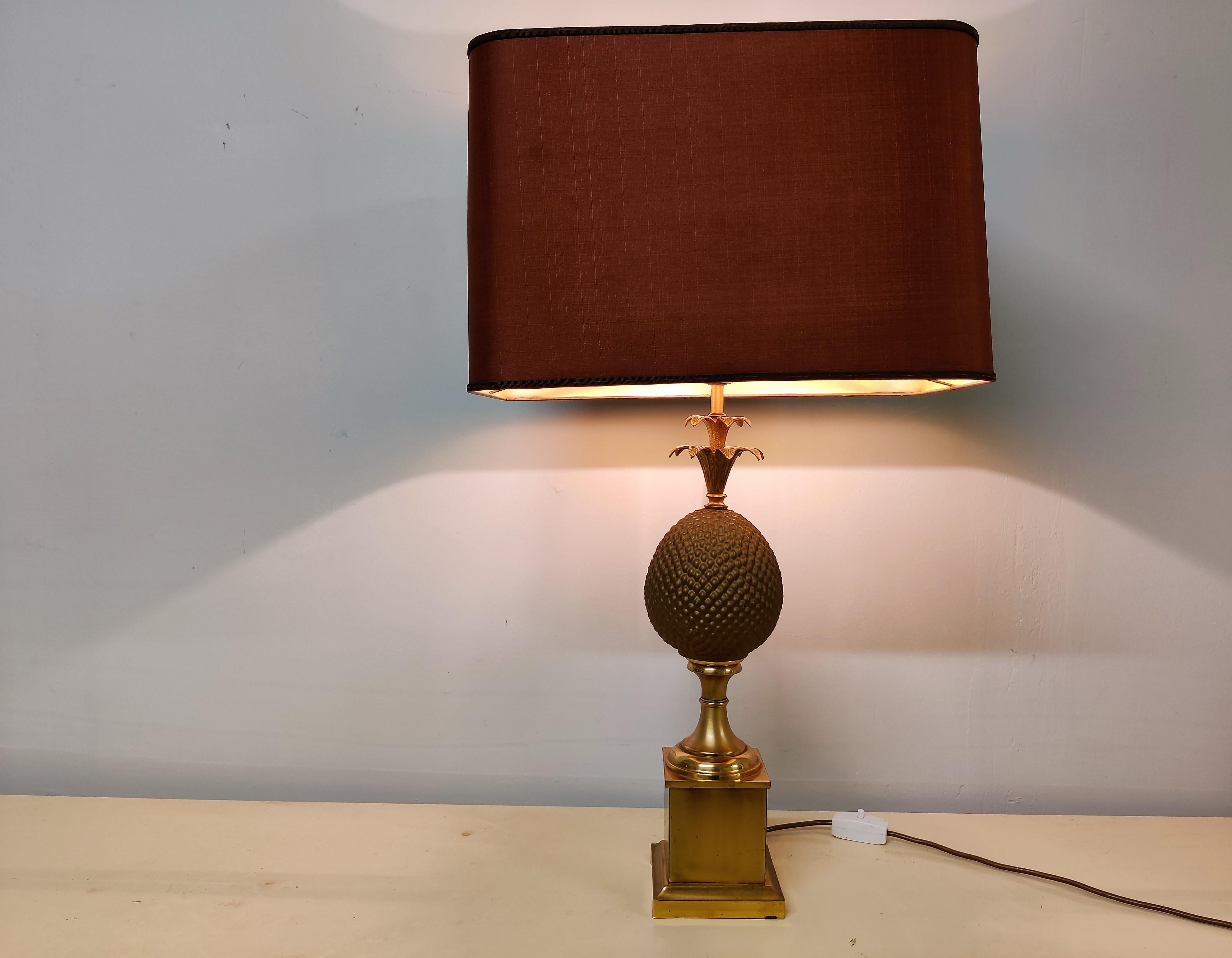 Elegant brass pineapple table lamp.

Beautiful details, right patina.

Supplied with its original bordeaux coloured shade.

1970s - France

Tested and ready for use. 

Good overall condition, slight wear on the base.
