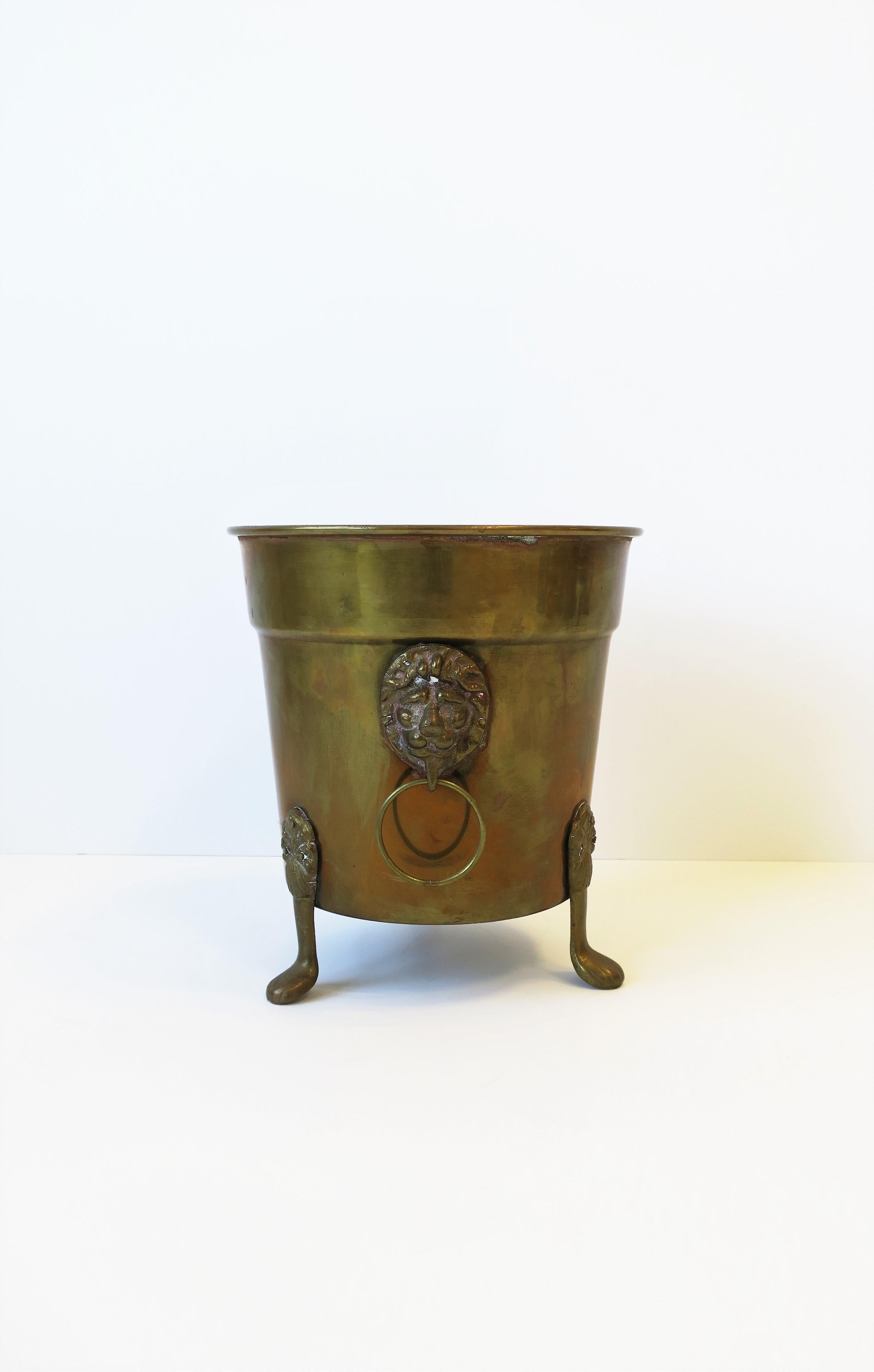 A vintage brass plant pot holder cachepot jardinière with Lionhead design, circa late-20th century. Dimensions: 8.5