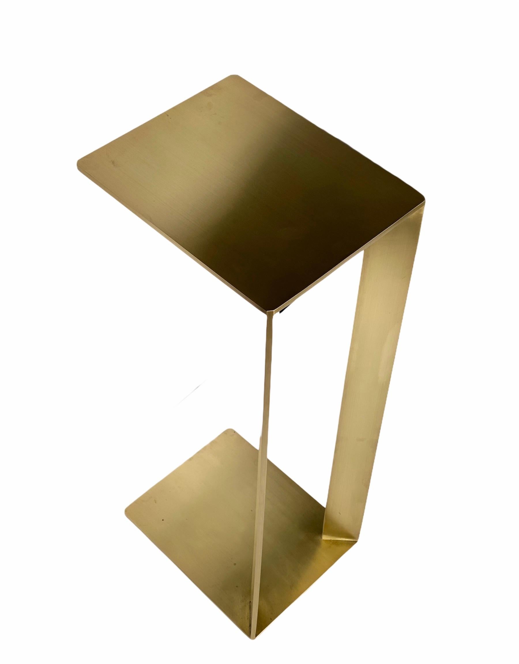 Bring warmth and luxury to your living space with this C-shaped accent end table. Crafted by hand with steel and finished in a rich plated brass satin finish. It's striking rectangular silhouette with clean-lines is perfect for any living room.