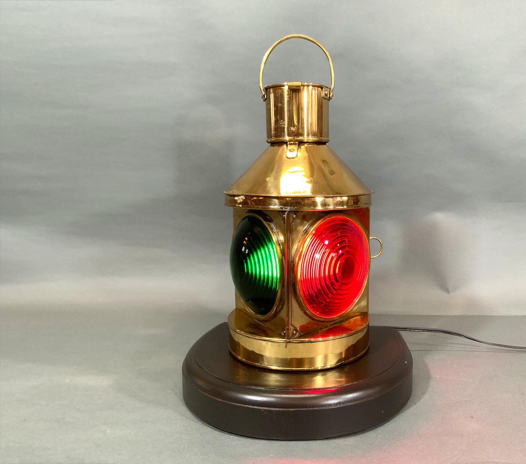 Solid brass port and starboard bow lantern from a boat. Very rare dual bullseye Fresnel lens design bow light in a highly polished solid brass case that is mounted to a mahogany base. Wired with electricity for home use. Impressed with Asian writing