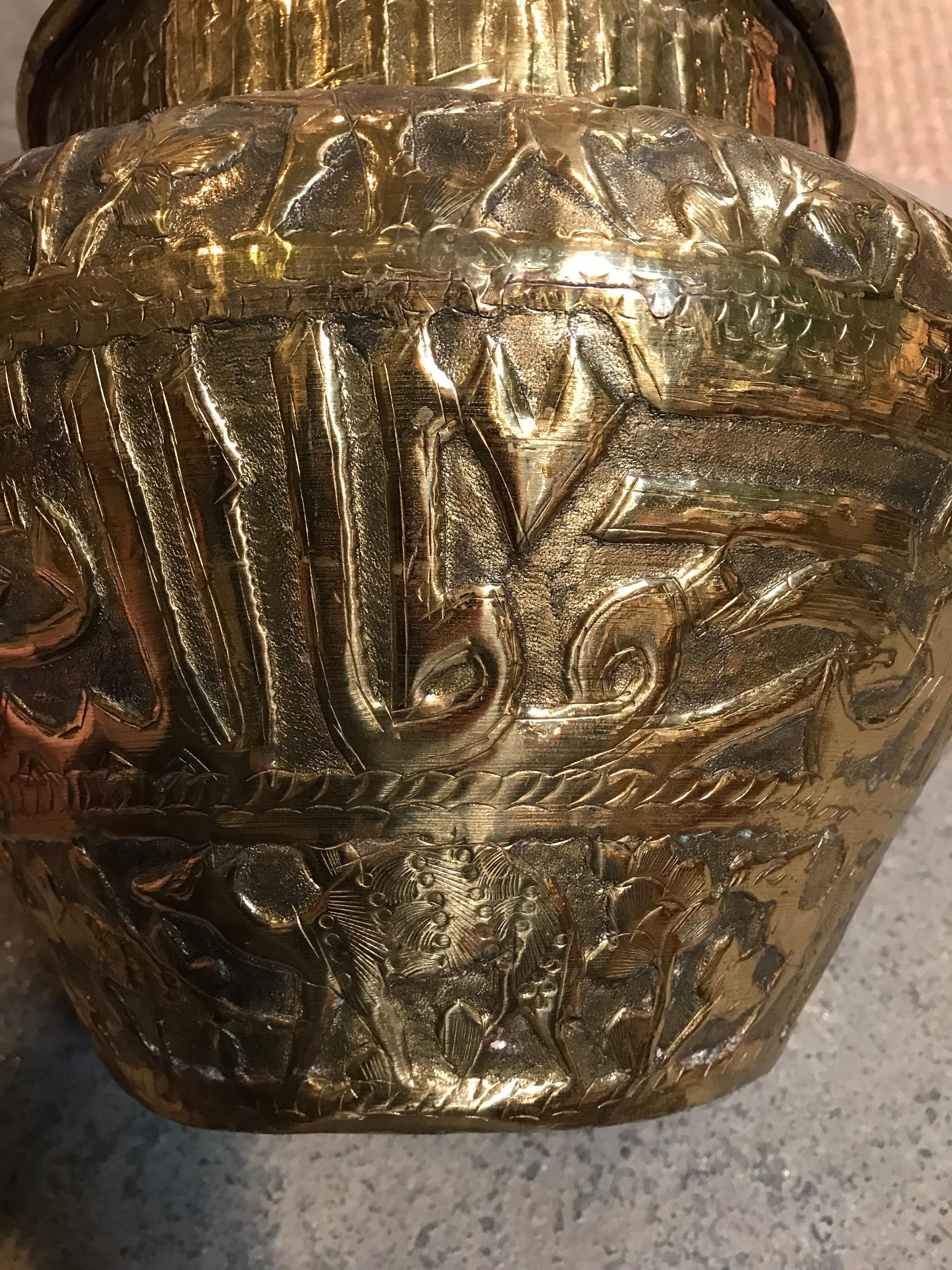 This ornamentally decorated pot is made of solid brass. The patterns on the hand-formed repousse and carved surface include various animal, deer and human like forms.