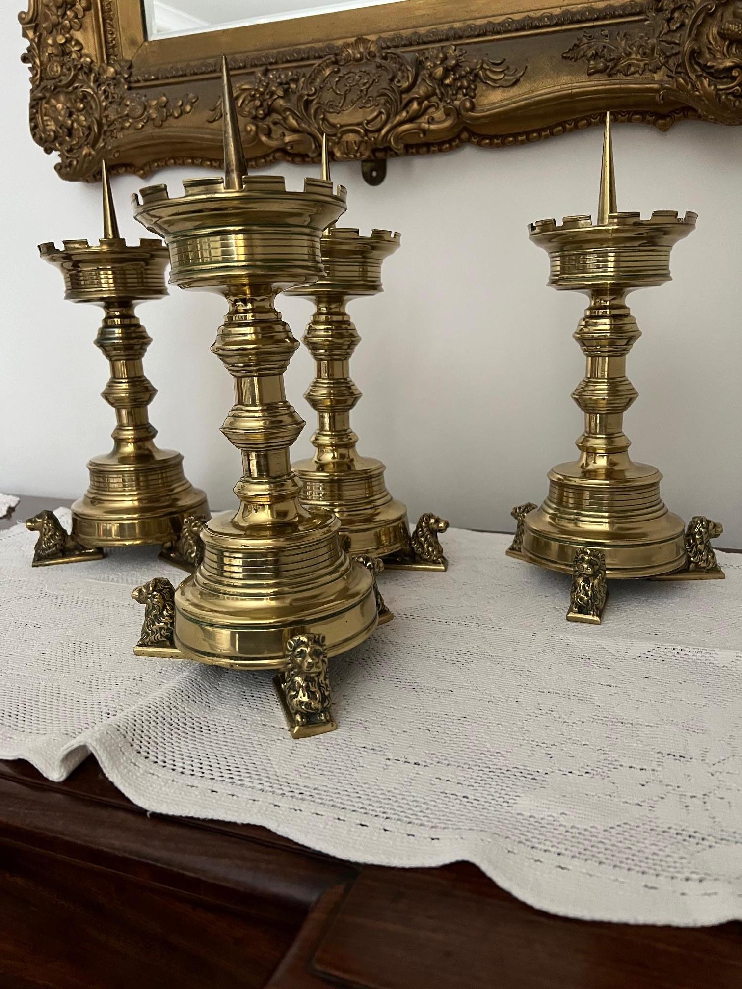 Quatre chandeliers hollandais en laiton du 19e siècle, avec des sommets crénelés. 

Tous ont signé sur les socles des lions. 
Signé avec ce qui semble être 