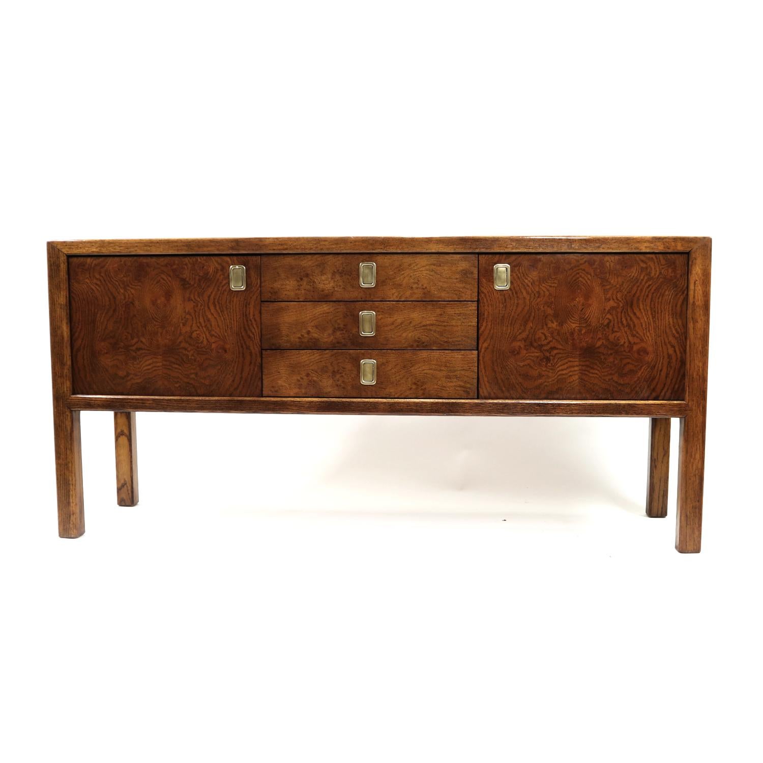 Stunning Campaign style credenza made by esteemed US furniture maker Century, circa 1970s. Mesmerizing burl wood on fronts and top. The brass pull hardware ties together British traditional, modern and Eastern design. We love these low profile, coin
