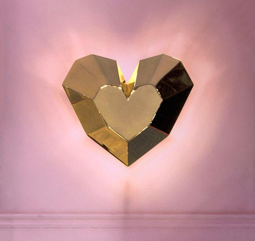Brass Queen Heart wall lamp by Royal Stranger
Dimensions: Width 30cm, height 26cm, depth 9cm
Materials: Glossy varnish on the gold leafed wood structure.

The projection of light behind the Queen Heart wall lamp is a warm golden and sweet glow