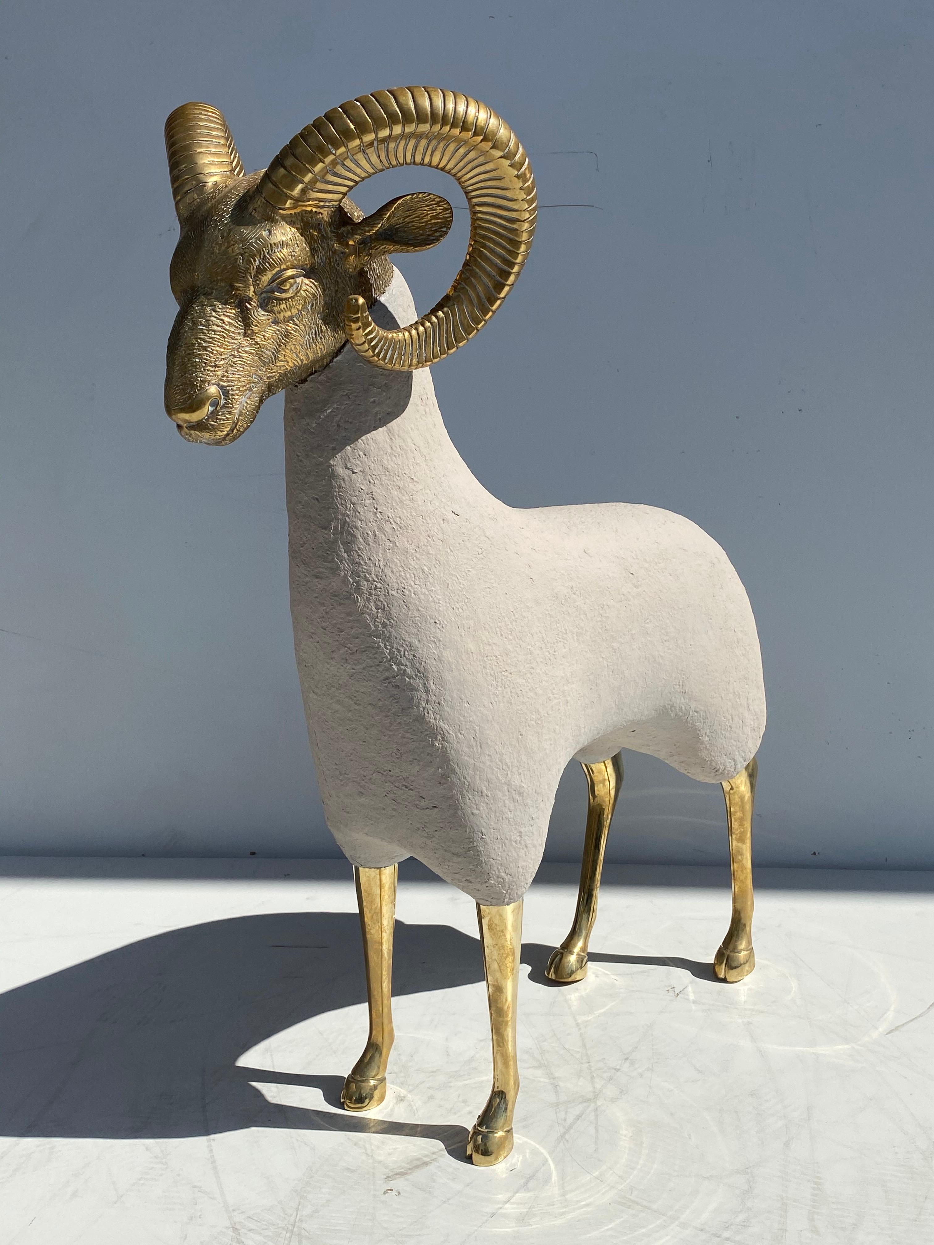 Brass ram or mountain sheep sculpture in faux concrete .