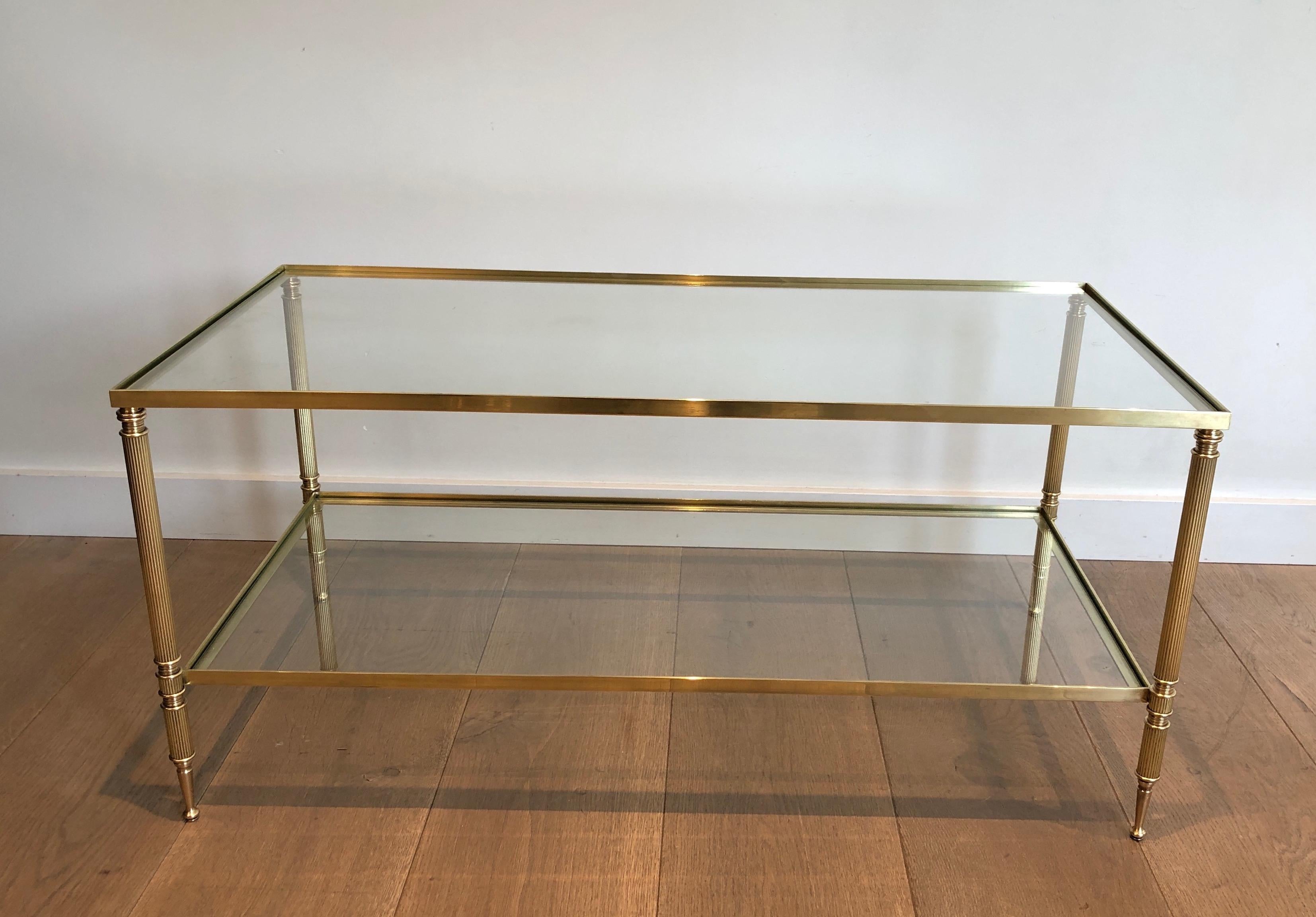 Esta mesa de centro rectangular de dos alturas y estilo neoclásico es de latón y tiene dos estantes de cristal. Se trata de una obra francesa del estilo de la Maison Jansen. Alrededor de 1940.
   