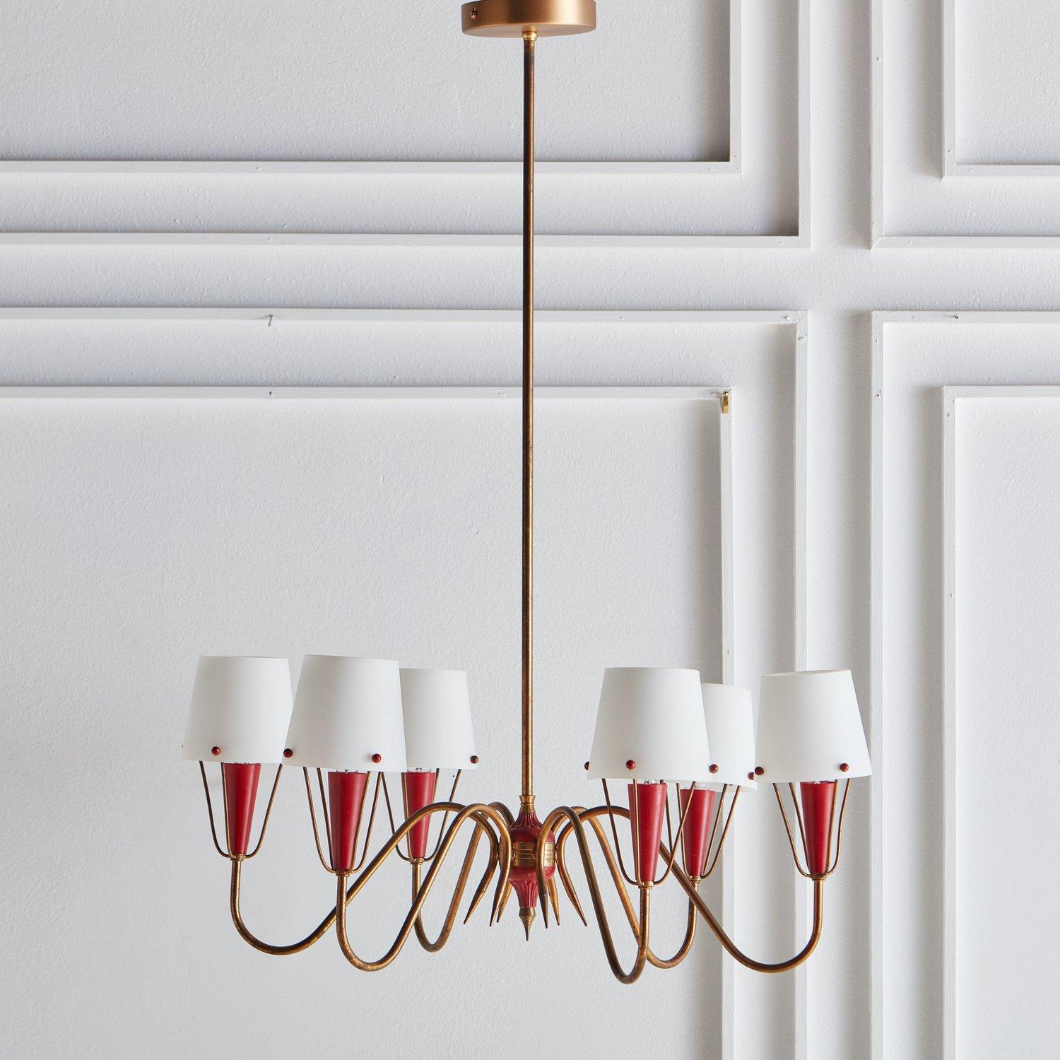 A gorgeous French 1950s patinated brass chandelier with acrylic red accents and six frosted glass shades. It has a brass stem and a new brushed brass canopy. This chandelier reminds us of the elegant style of French designer Jean Royère. Sourced in