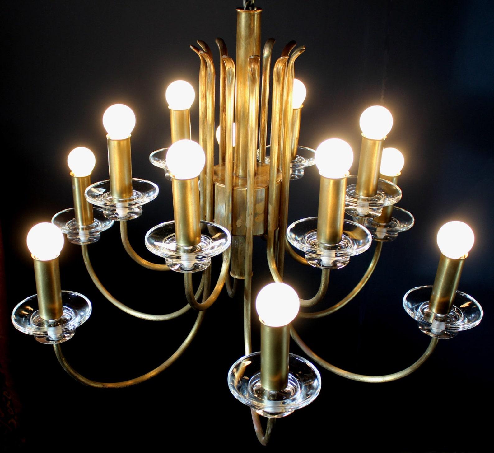 12 Lights (e14) minimalistic German brass chandelier 1950's.

The chandelier impresses with clear forms, noble materials and perfect craftmanship. It is in nearly perfect original condition and was carefully cleaned and rewired. The aged and