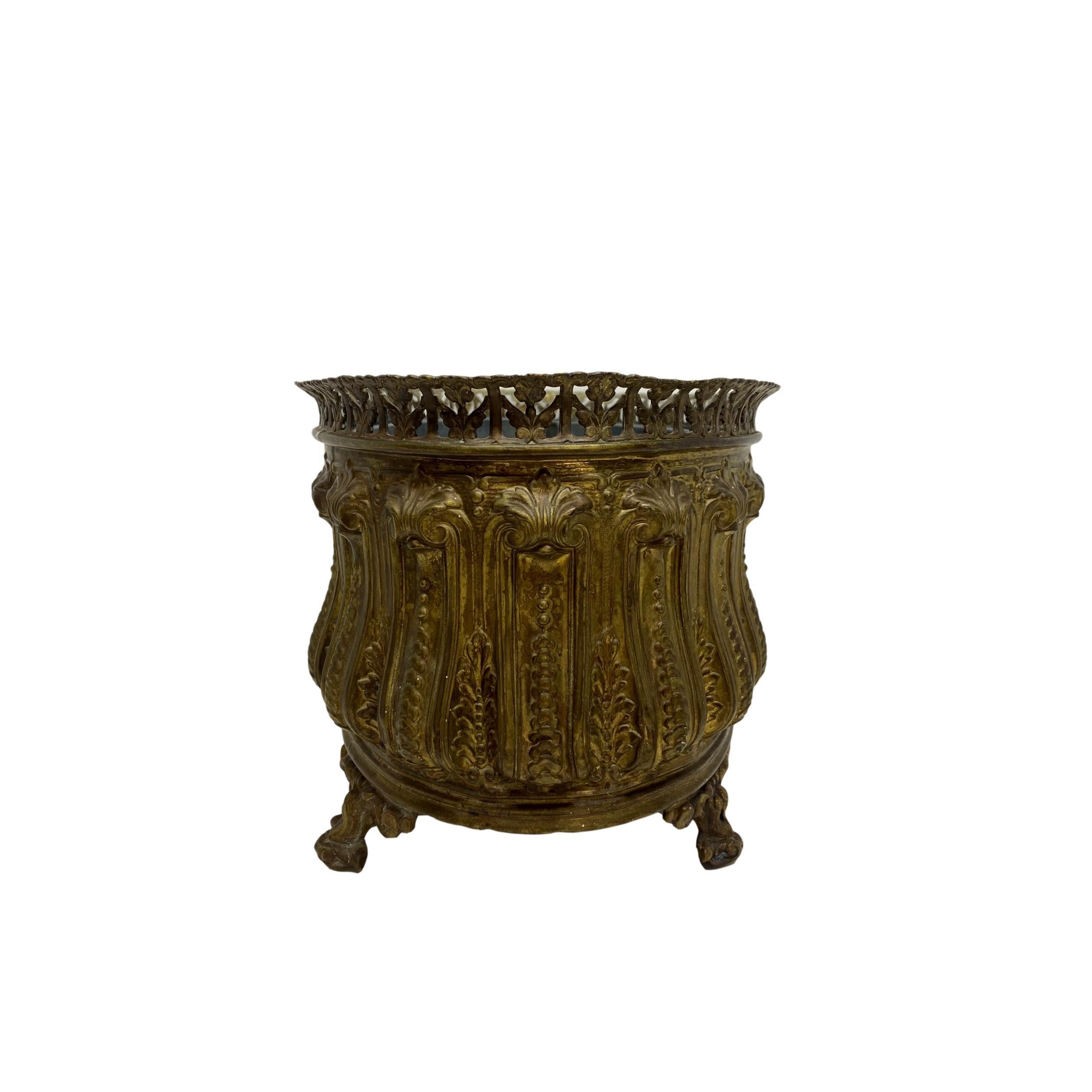 Hand-hammered brass repousse cachepot/jardiniere with original zinc lining, French, Second Empire, ca. 1860, the oval body formed by highly stylized channels and resesses, with a fillagreed rim, on ornate solid brass feet.