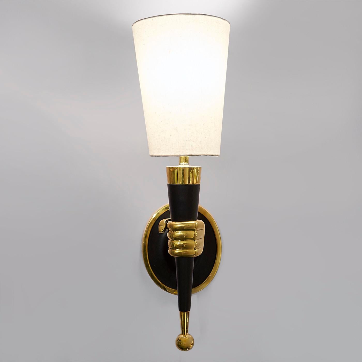 Surrender to the surreal. Available in left or right hands, each sconce is sand cast in brass with blackened accents. The inverted shade completes the torch-like effect. Fab in a dining room or ultra-intriguing in a foyer. The original brass hand