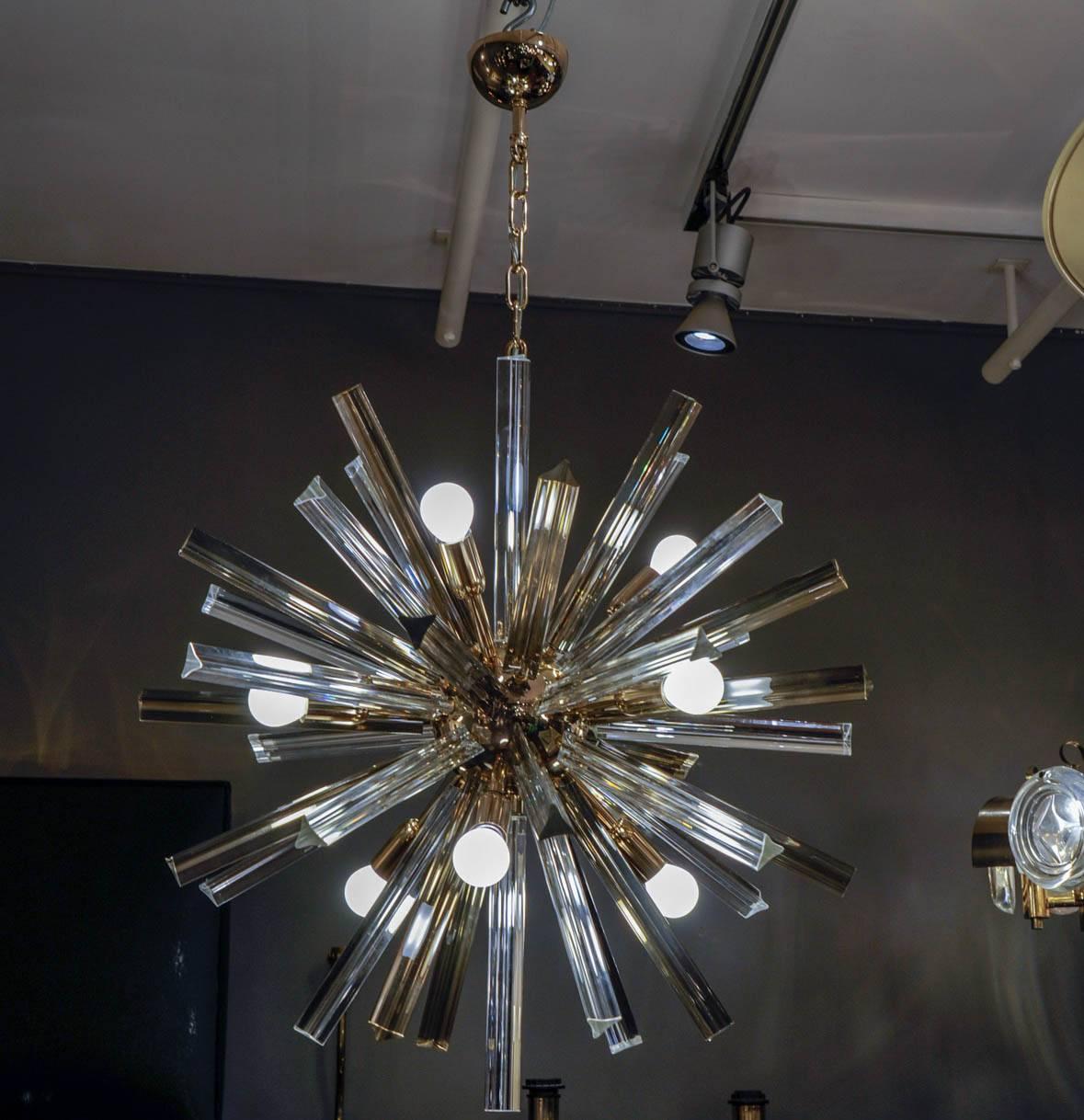 Nice small round chandelier made of brass structure with nine lights, and two colors triedre Murano spikes.