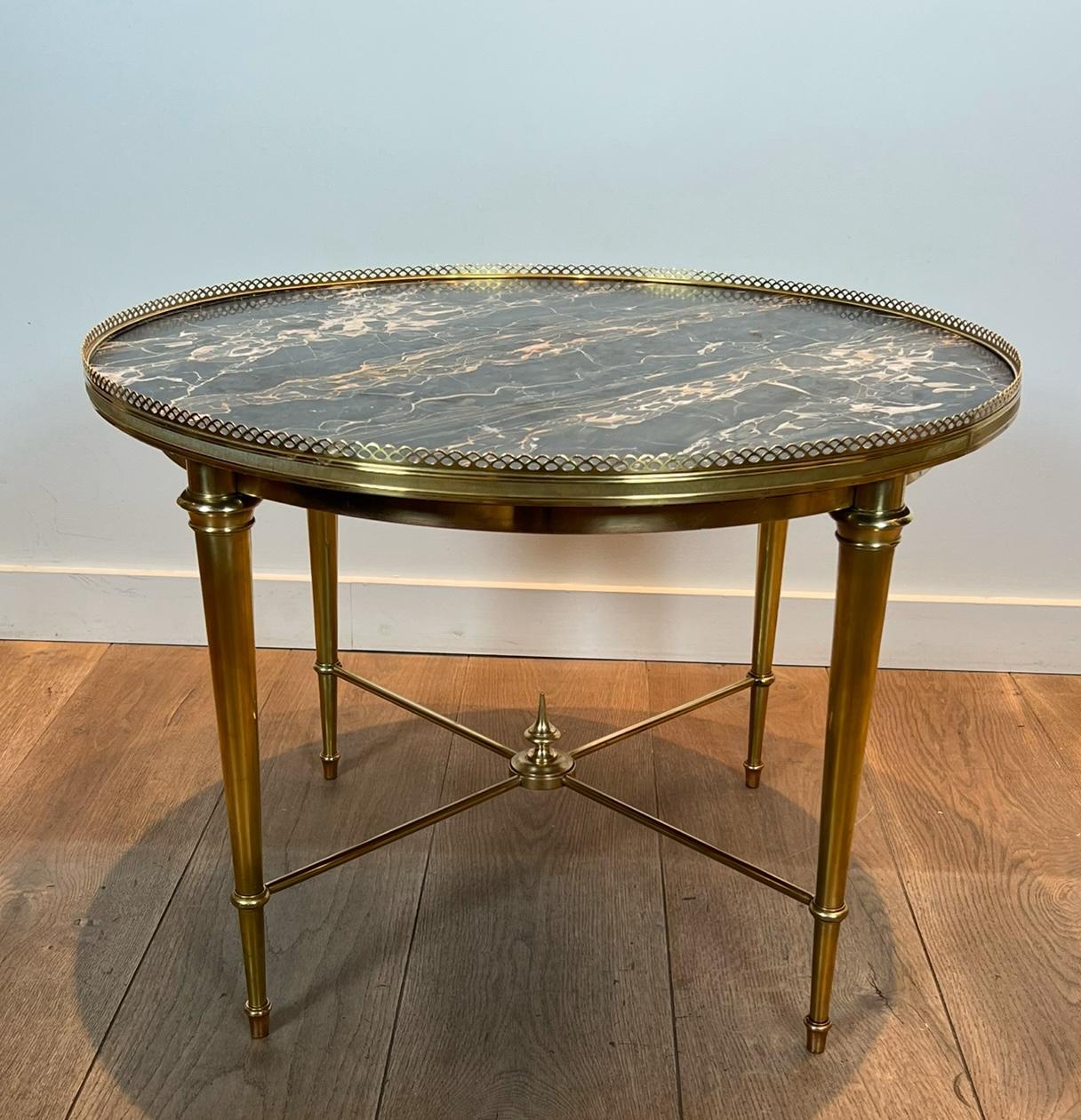 This beautiful neoclassical style round coffee table is made of  brass with a beautiful marble top. This is a French work by Maison Ramsay. Circa 1940