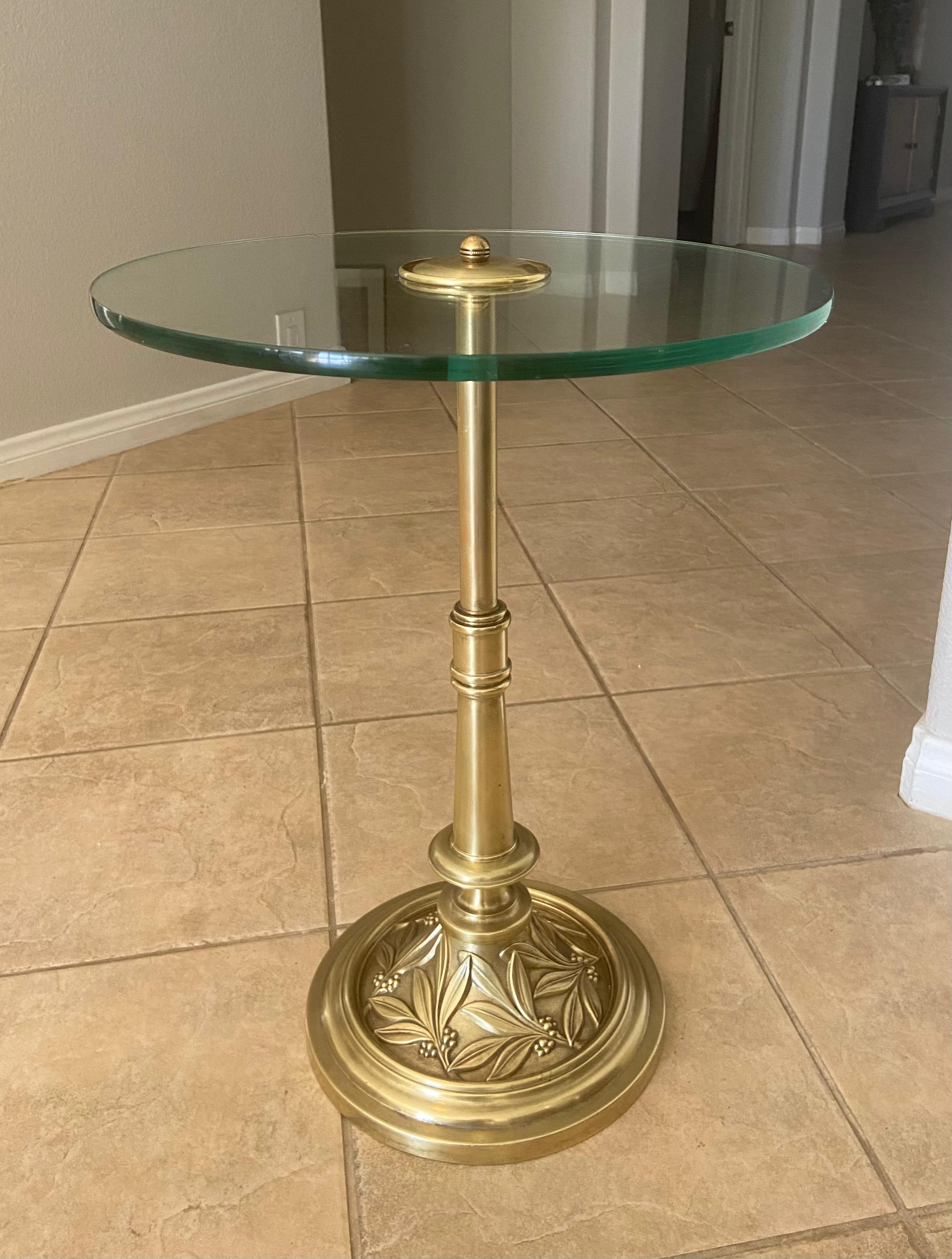 1940s brass round side table (or end table) with embossed leaf design detailing on base. Round glass is 17