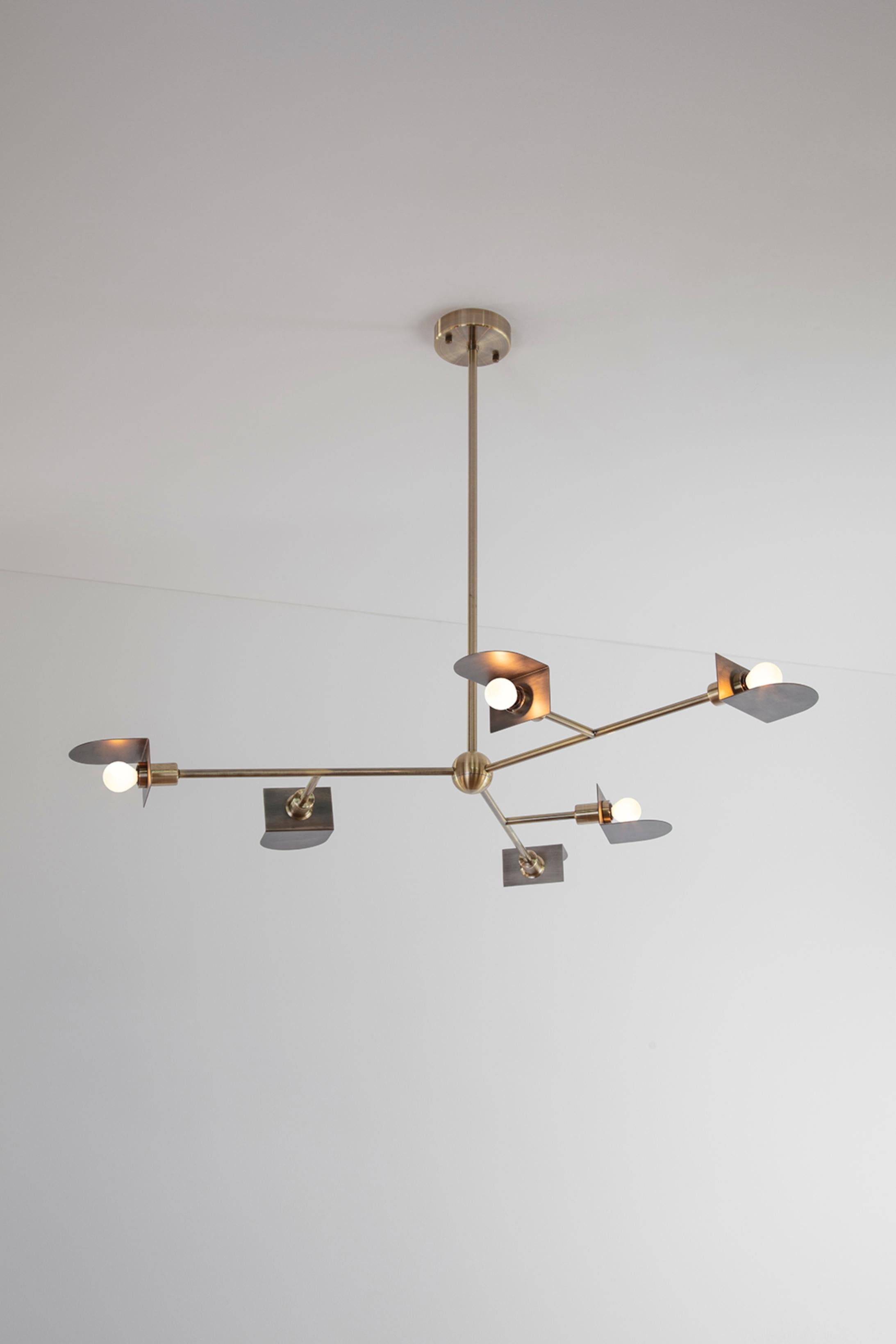 Brass Route II Chandelier by Square in Circle
Dimensions: W 110 x H 55 x D 110 cm.
Materials: Brushed brass finish and dark grey metal.

An ambitious chandelier with geometric semicircular metal shades with returns crafted from metal. This three -