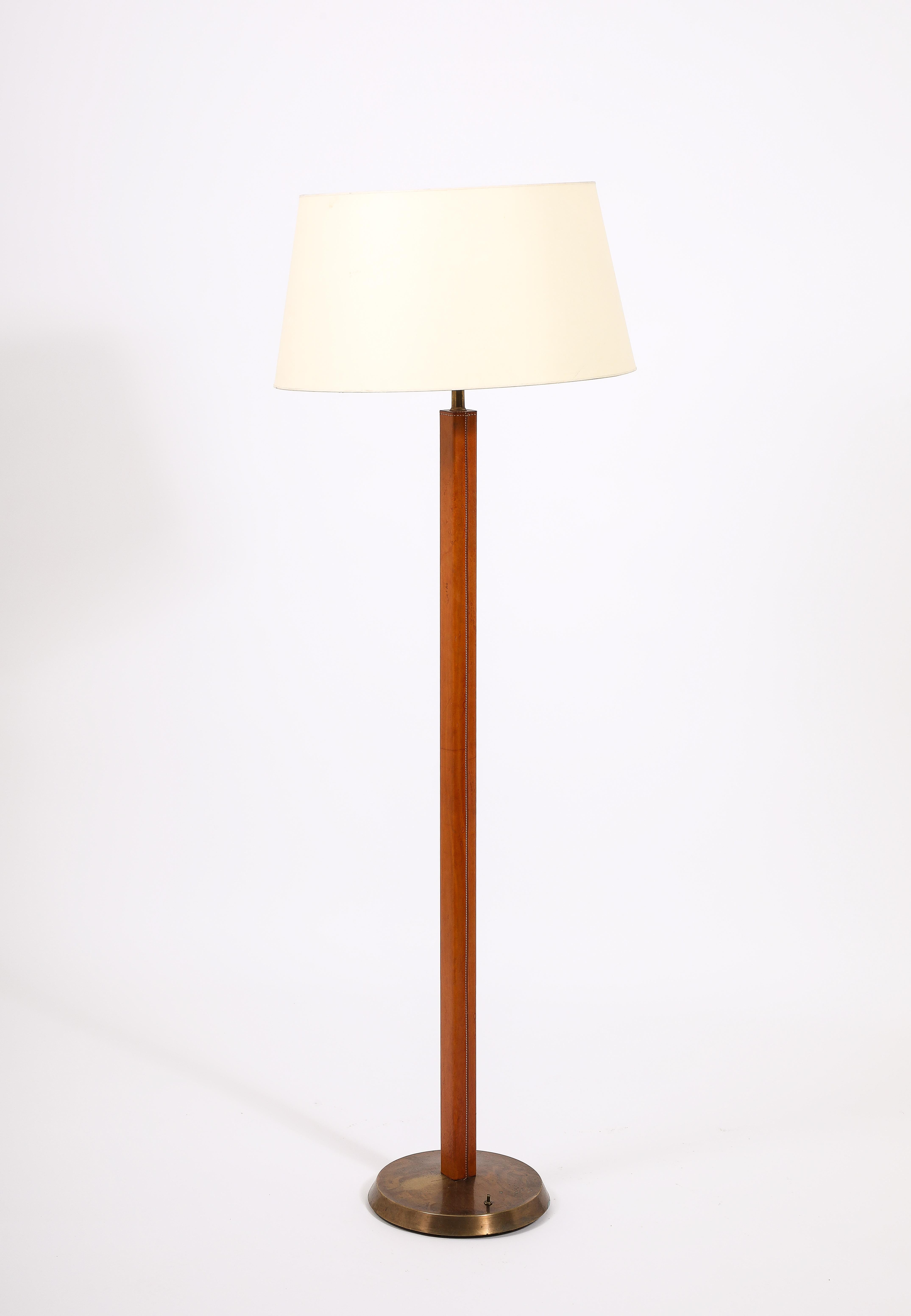 Elegant floor lamp in brass, the large square stem wrapped in a rich tobacco colored leather. Base is 9