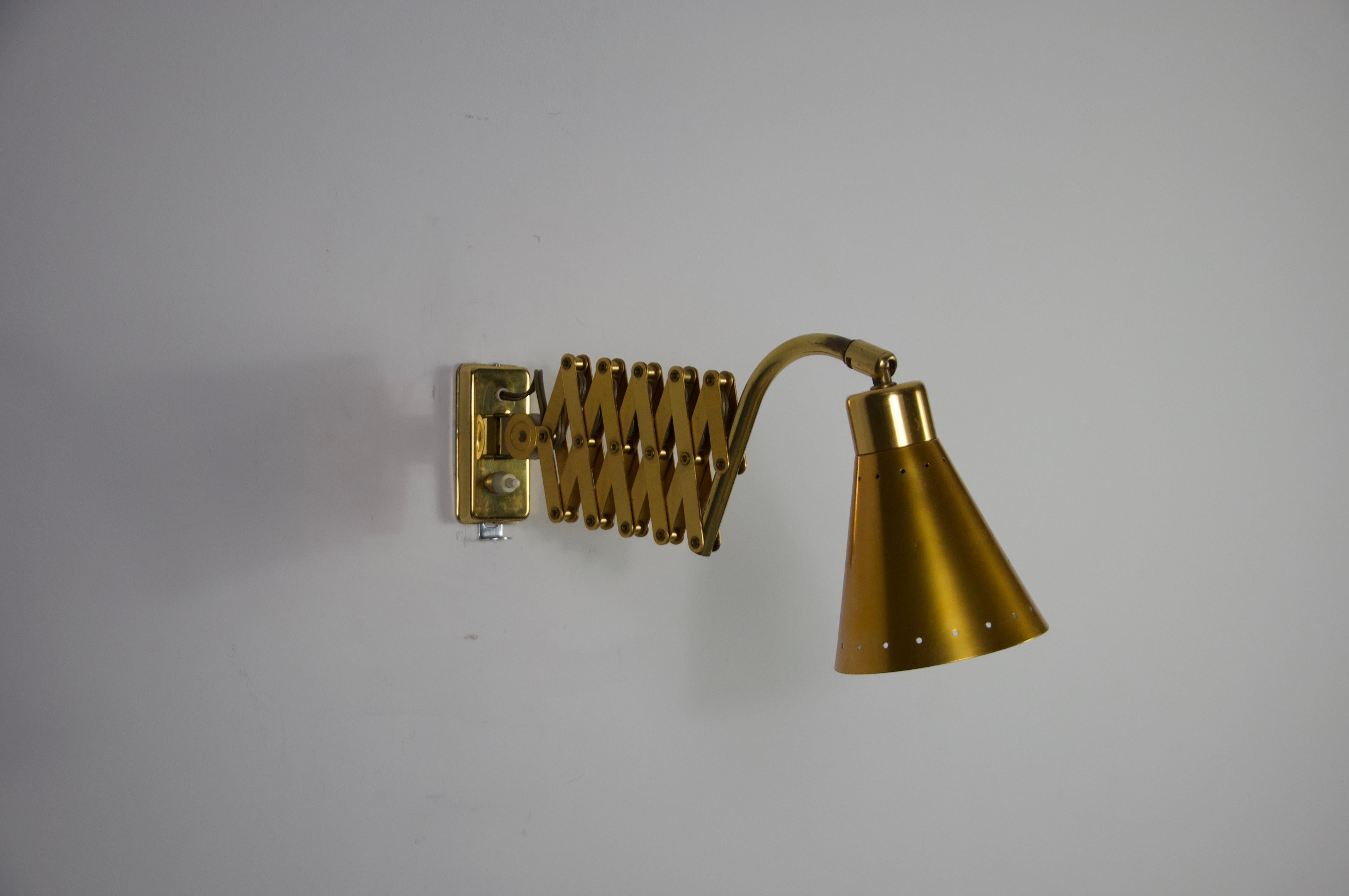 Questa lampada da parete a forbice proveniente dalla Germania, risalente agli anni '60, è un classico del design funzionale della metà del secolo scorso. La lampada è dotata di un braccio estensibile a fisarmonica che permette di regolare la luce