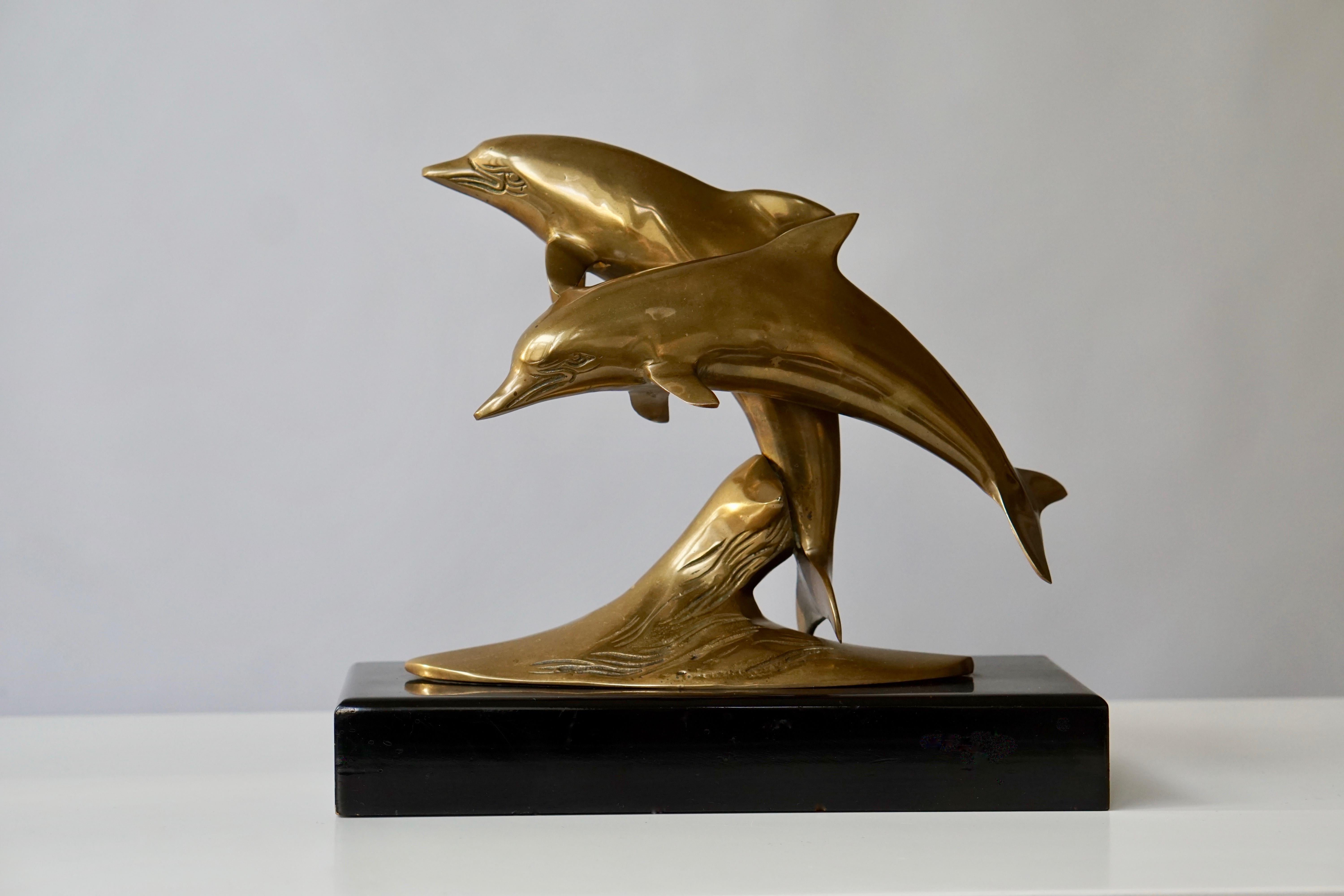 Brass sculpture of dolphins on a wooden base.
Measures: Height 24 cm.
Width 27 cm.
Depth 11 cm.