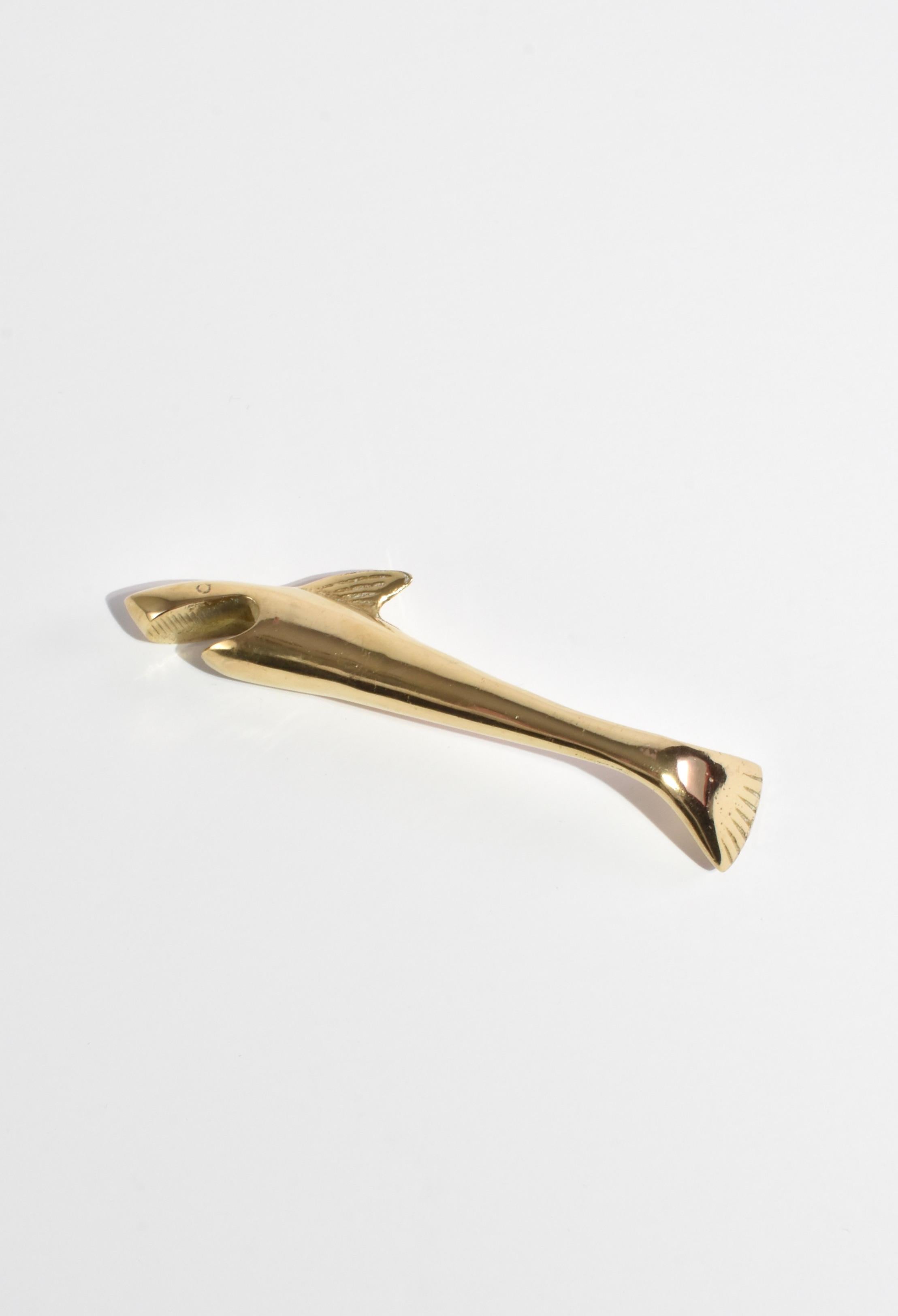 Vintage brass bottle opener in the shape of a shark.