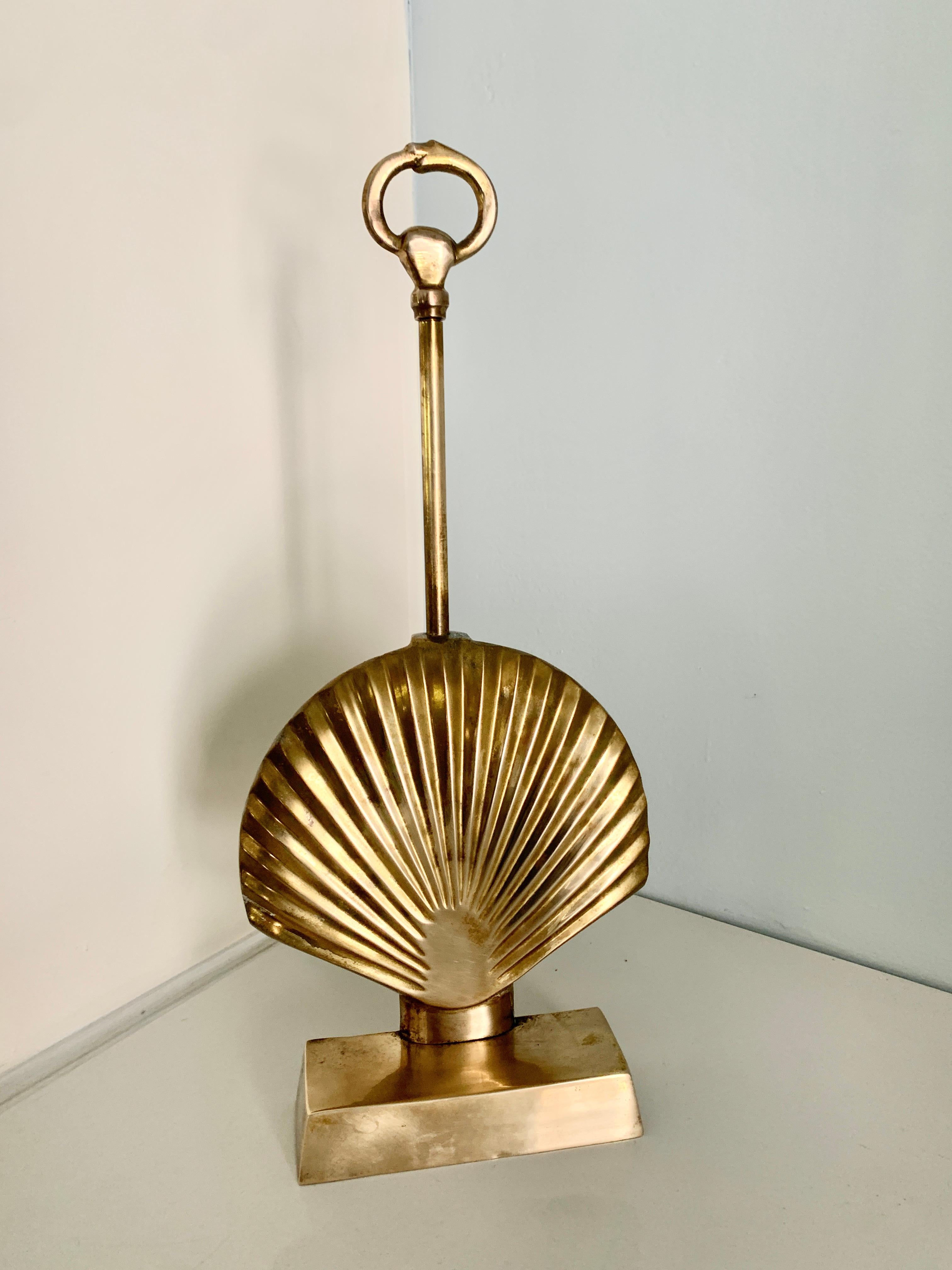 A solid and heavy Brass Shell Shape door stop with handle. Door stops are essential when a breeze coming through your space continually slams a door shut, or in this case, we also recommend a purely decorative stylish stop. 

With many stops