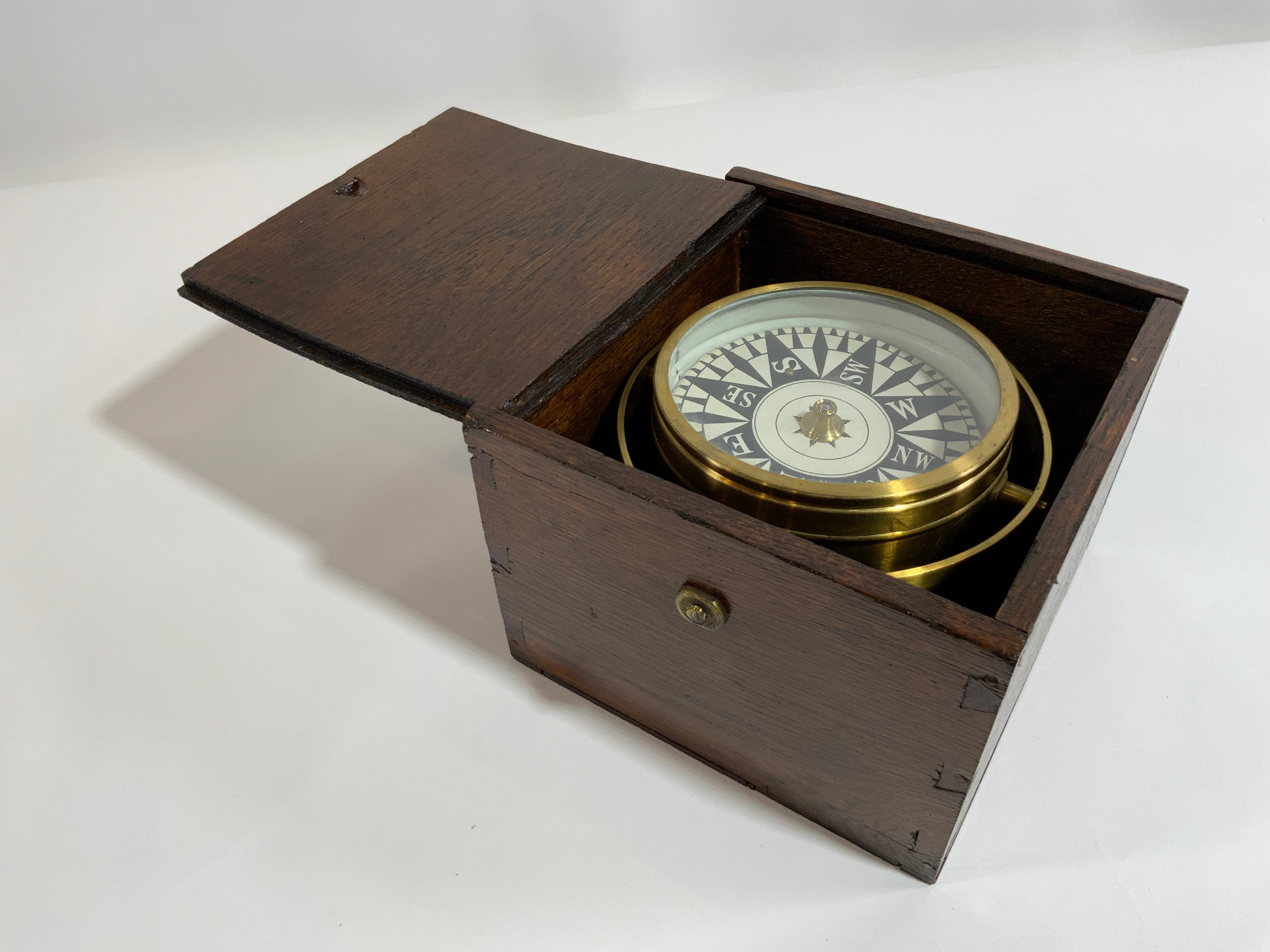 Late nineteenth century ships compass with gimbal mounted into a varnished wood box. Compass card in very nice condition and marked with a large fleur-de-lis pointing north. Spun brass bowl. Circa 1880.

Overall dimensions: 6