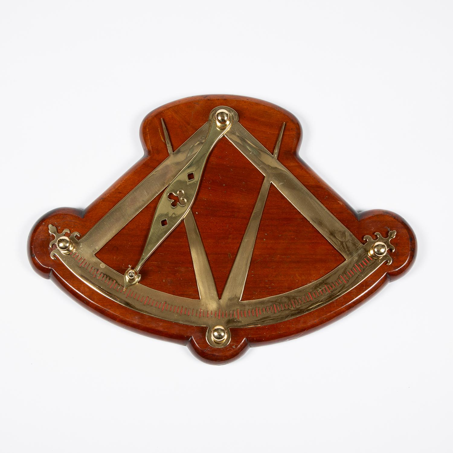A wall mounted 1920's brass ship's inclinometer in the form of a quadrant and dividers, on a moulded mahogany back board.

Scale in degrees from the vertical to 45° of tilt/list.

An inclinometer, or clinometer, is an instrument used for measuring