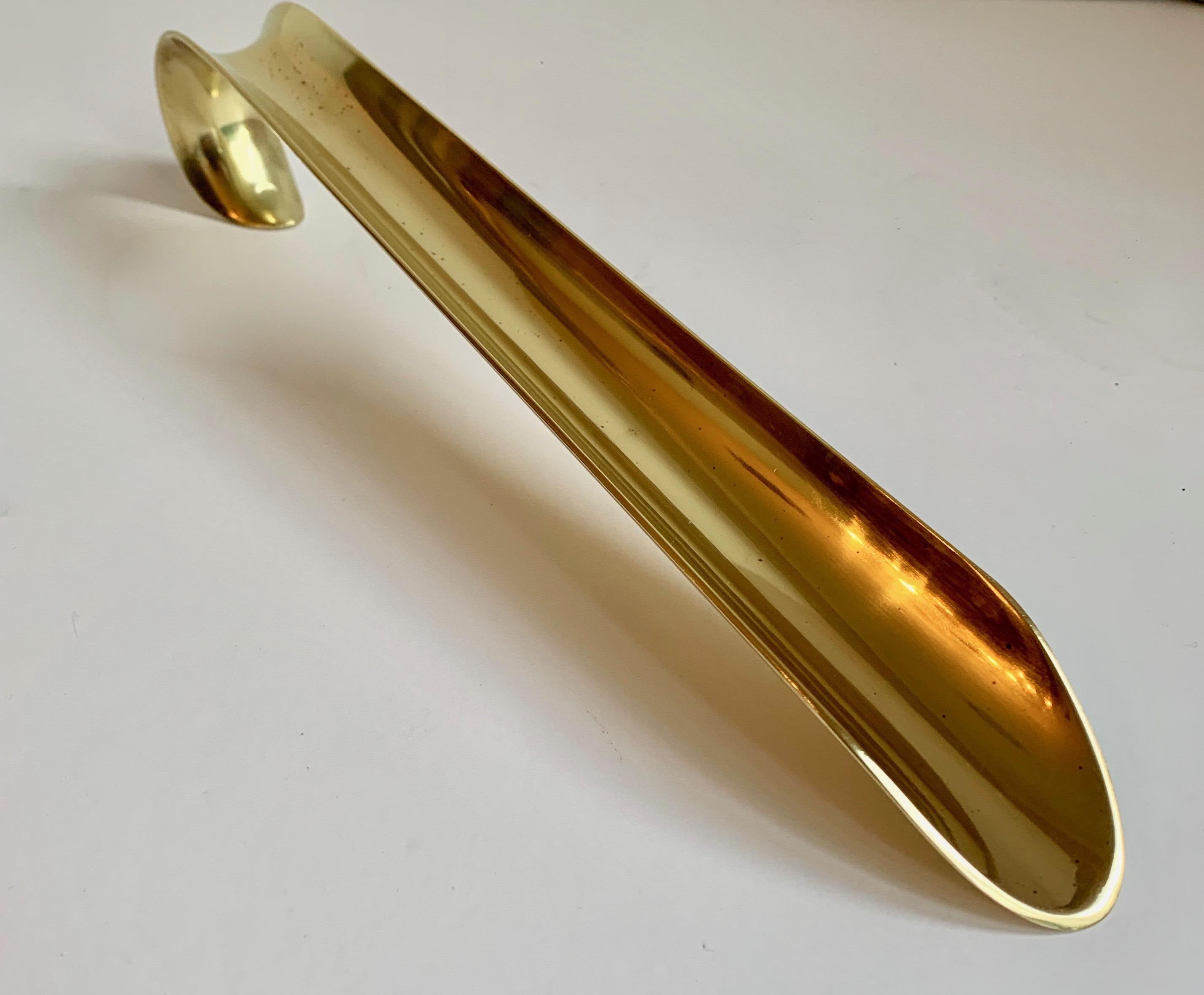 A monumental and very solid brass shoe horn. Definitely for the shoe or boot that has you in a bind as this piece is long, solid and will get the job done!

A very nice and well made brass horn - with a nice curl as the end to grip and store.