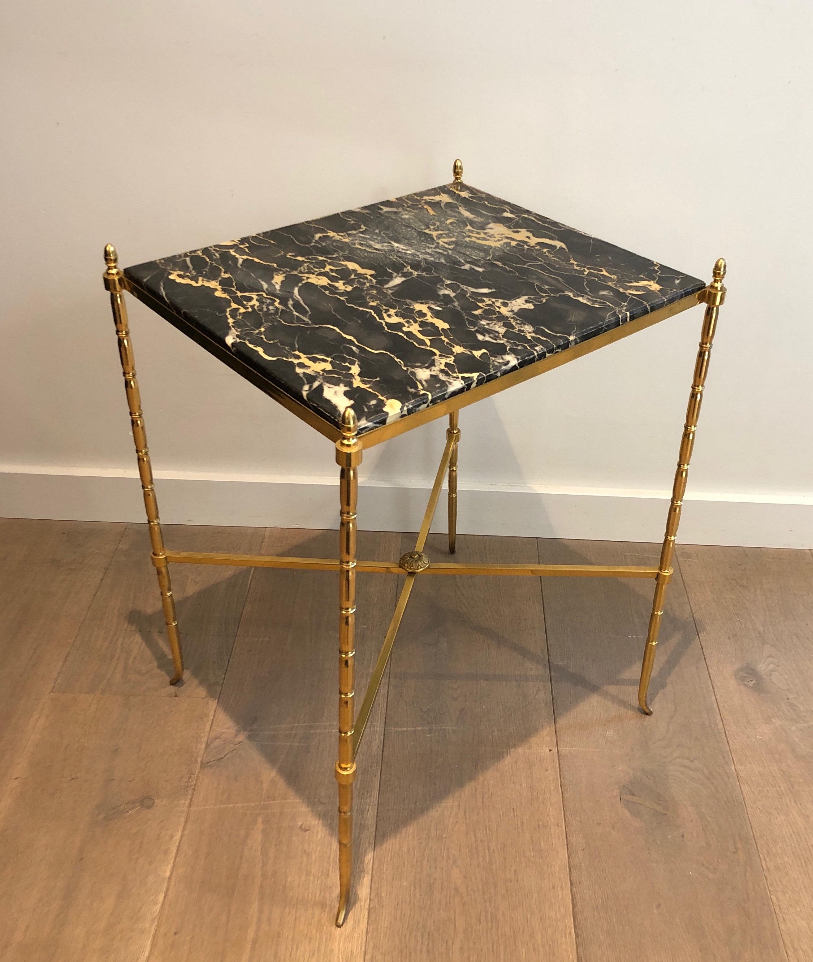 This faux-bamboo side table is made of brass with a black marble. This is a French work by famous Maison Baguès. Circa 1940.