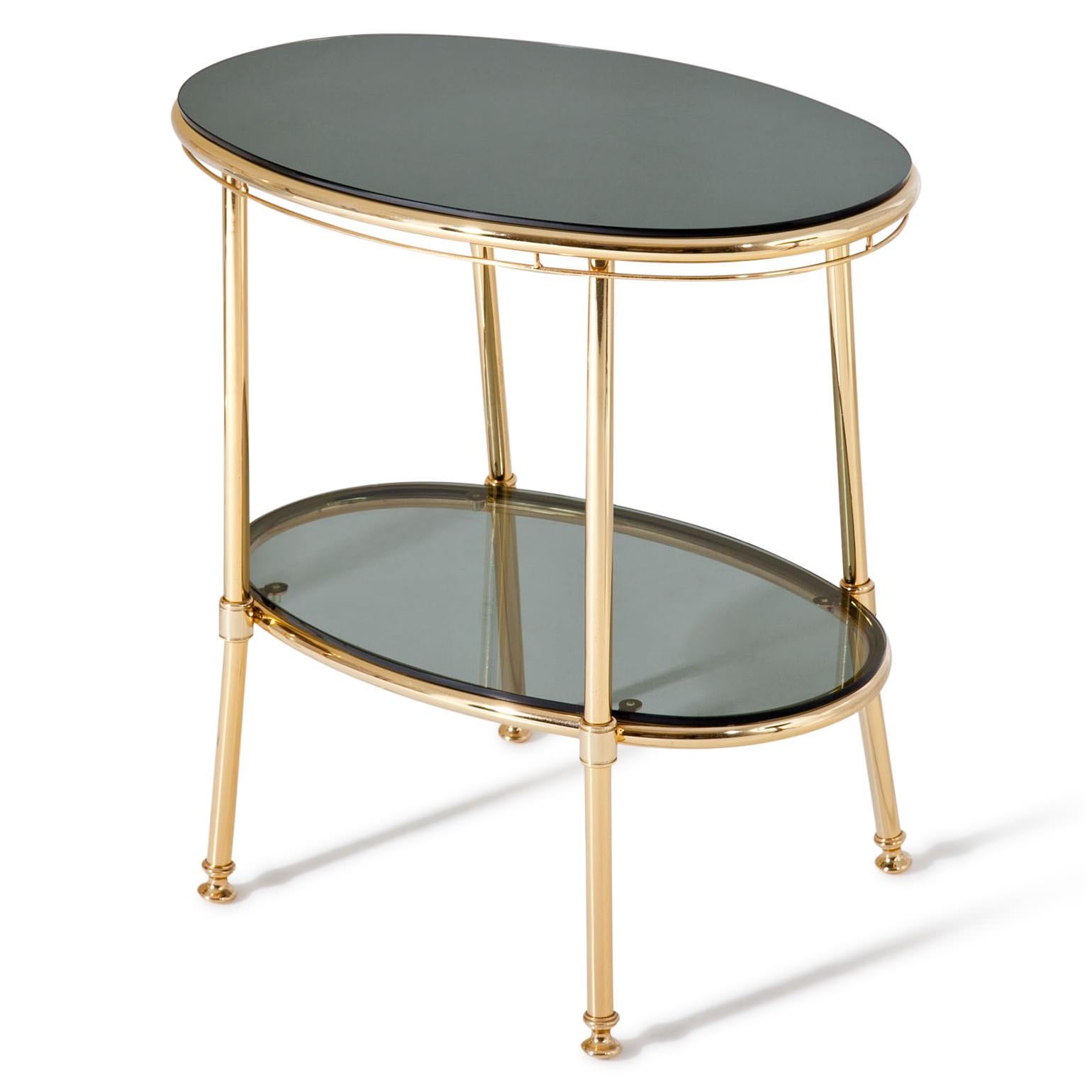 Pair of side tables or nightstands out of brass with an oval shape and two shelves out of dark glass. The top one is mirrored. Very nice quality.