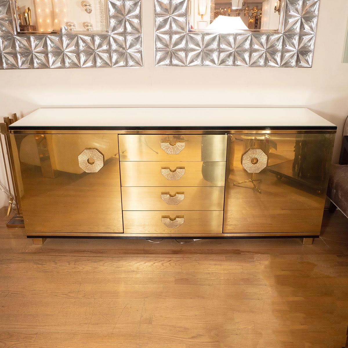 Brass sideboard with four drawers and two doors with decorative textured details.