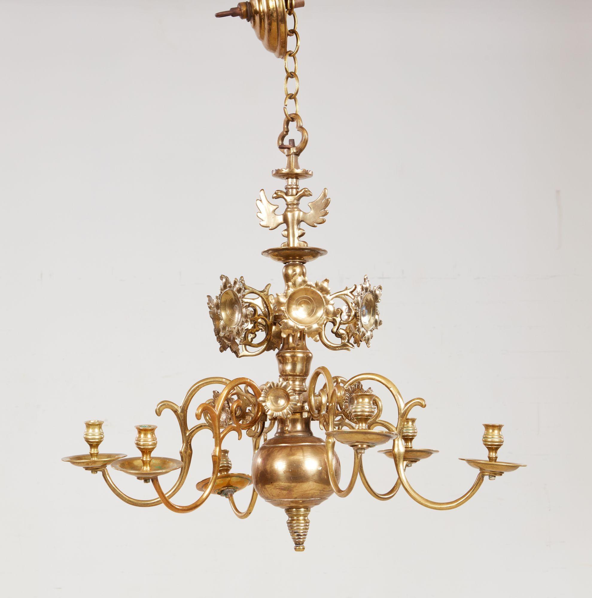 Raffinato lampadario a sei luci in ottone del XVIII secolo con terminale a forma di aquila su sei riflettori a testa di fiore sopra sei bracci in ottone a volute che conservano i portacandele originali e le vaschette di raccolta sopra la goccia a